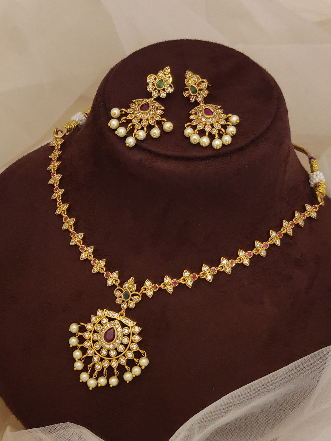 Traditional South Indian gold plated necklace set by Abdesignsjewellery with red stone pendant pearls and matching earrings