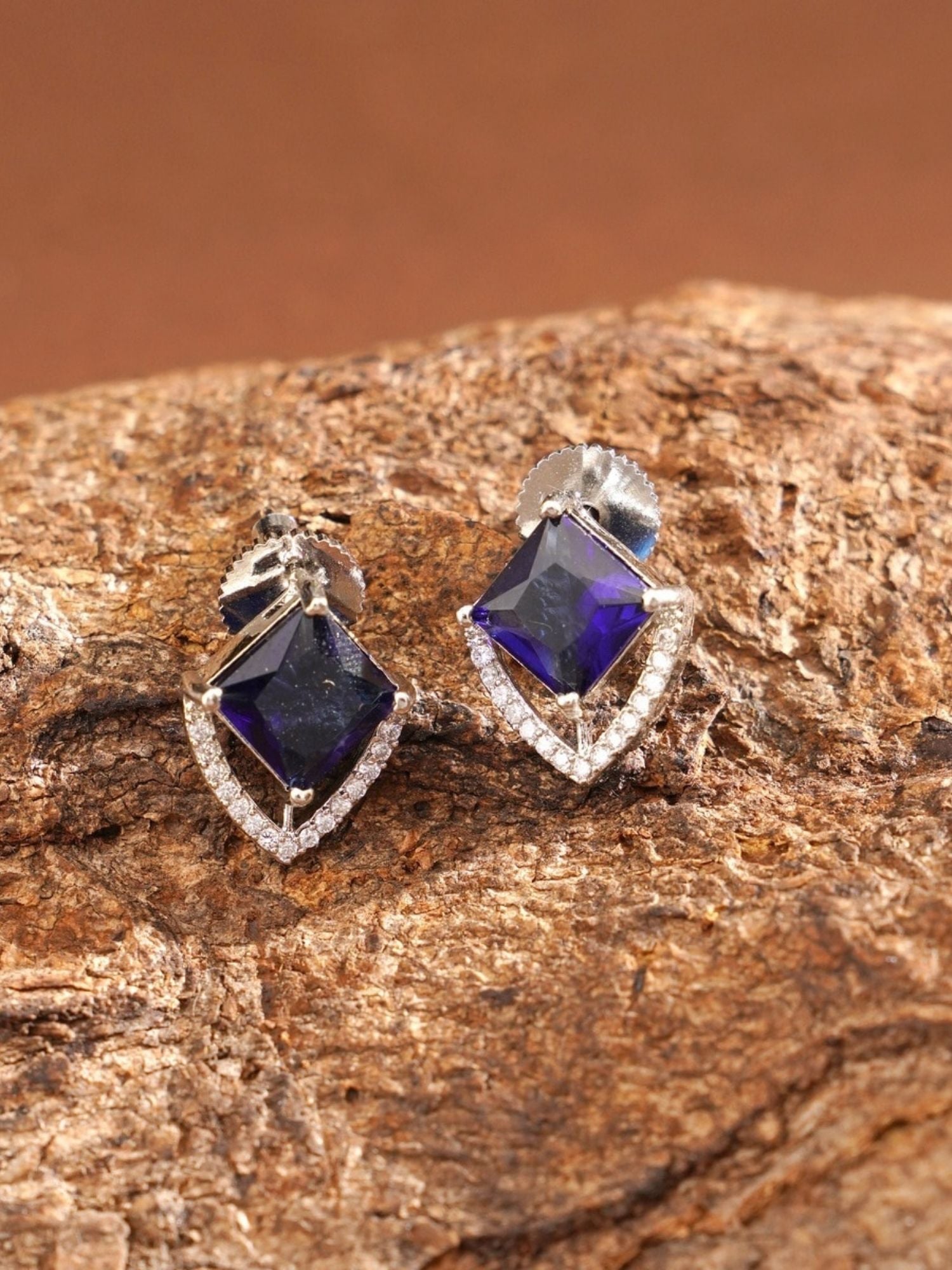 Unique Silver Plated American Diamond Stud Earring with deep blue stones and intricate design on textured surface