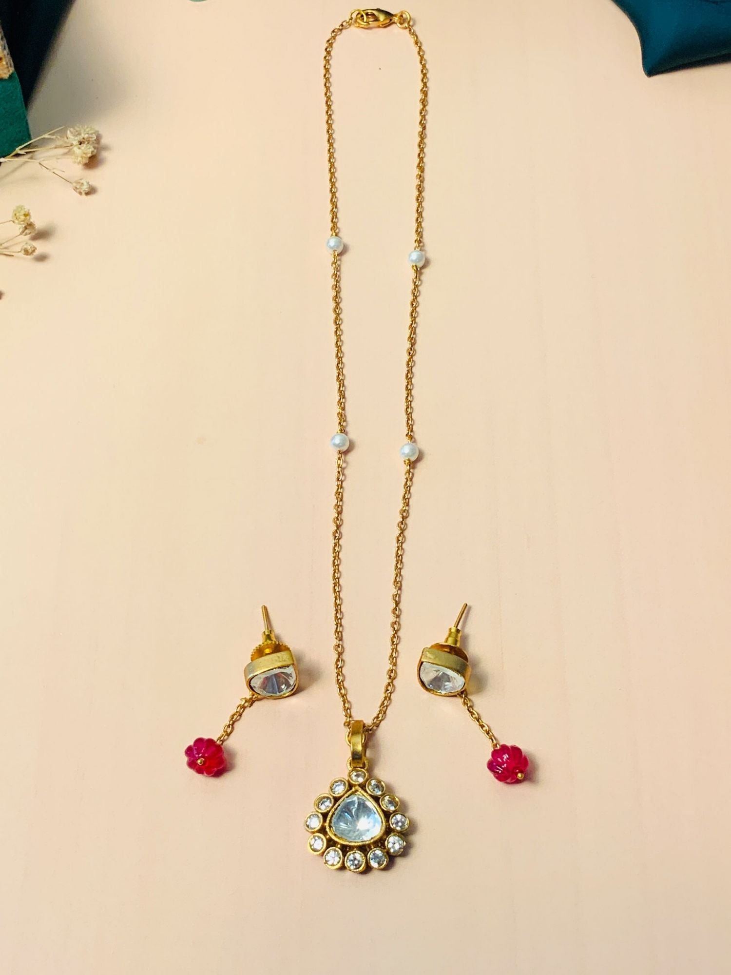 Vibrant Gold Plated Polki Pendant Chain With Earrings featuring teardrop polki pendant pearl accents and red bead danglers