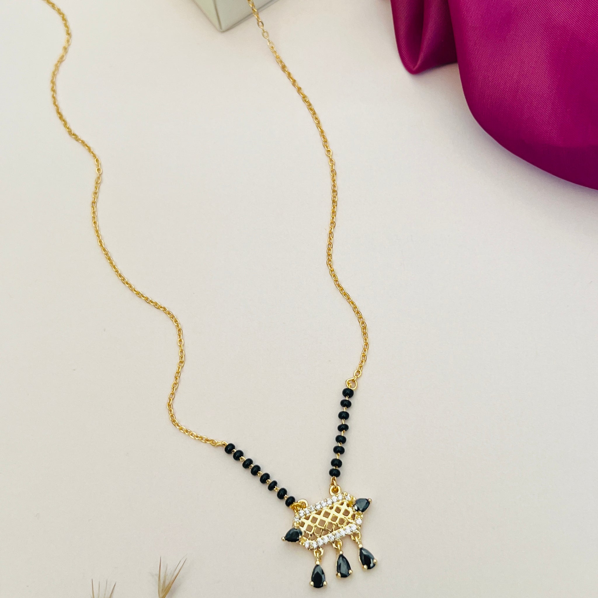 Abdesignsjewellery American Diamond Mangalsutra with black beads and gold pendant on white background