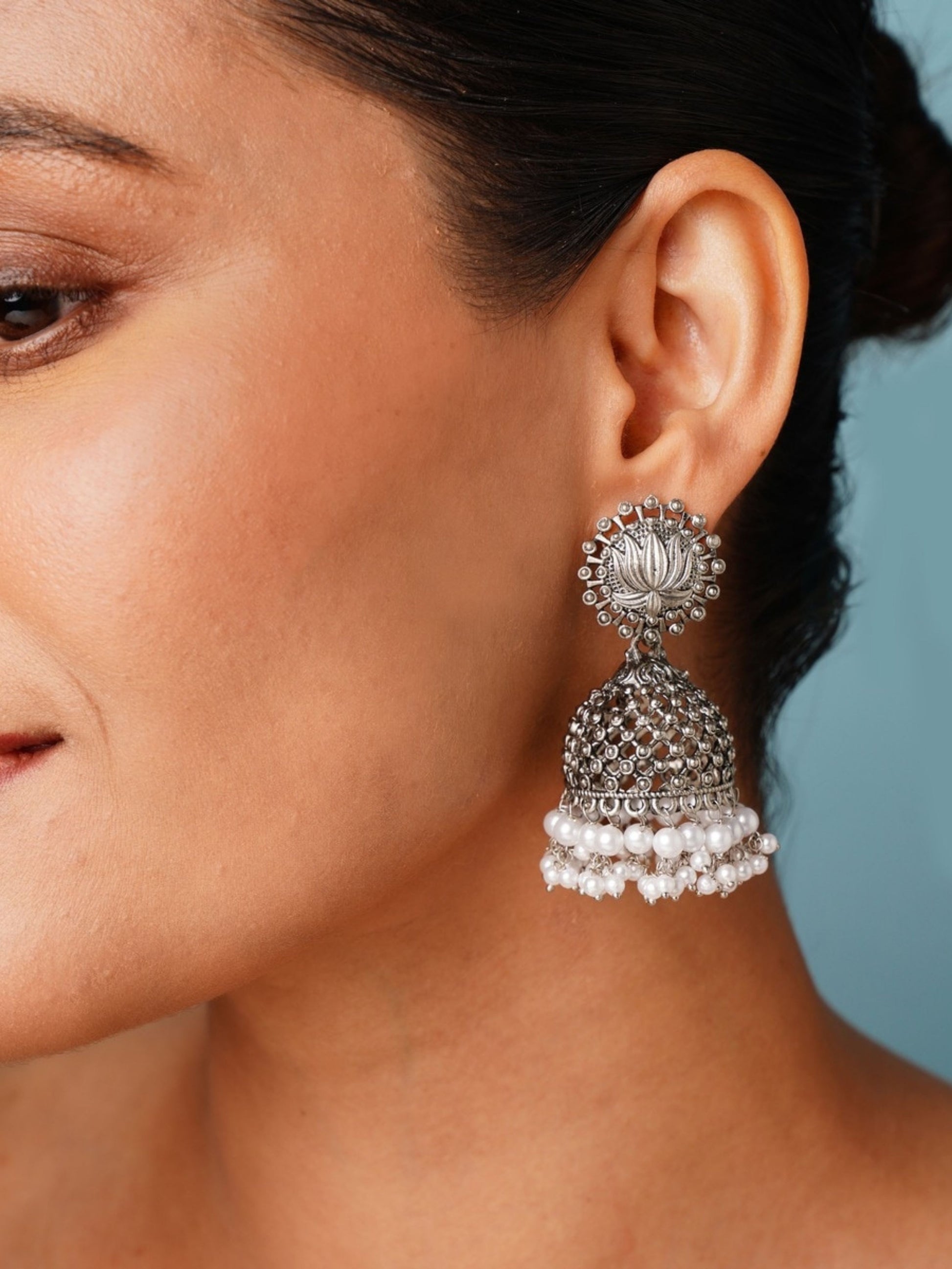 Classic German Silver Pearls Jhumka Earring by Abdesignsjewellery worn on woman's ear with intricate detailing and pearl accents