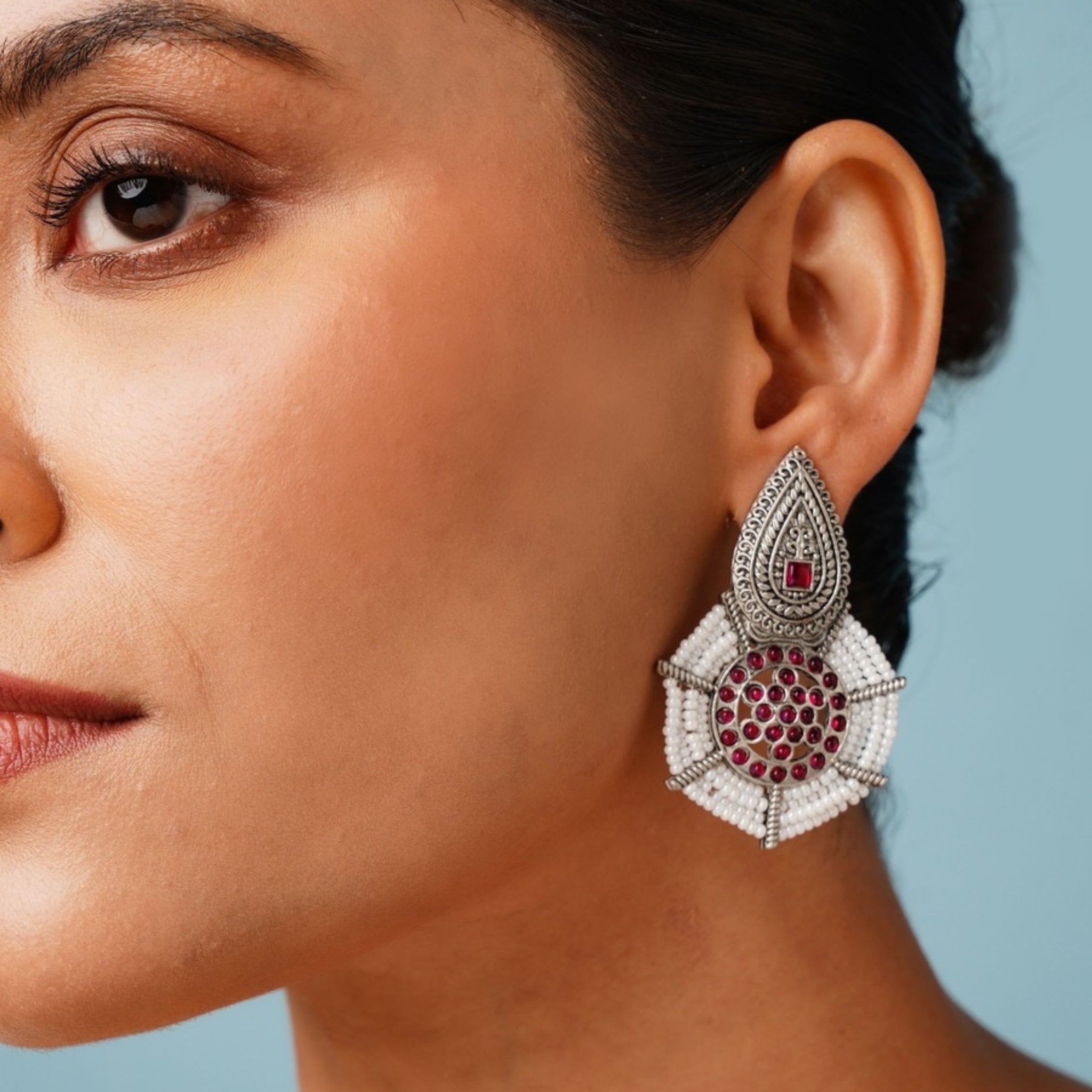 Abdesignsjewellery German Silver Pearl Earring with intricate design and red gemstone accents worn by a woman