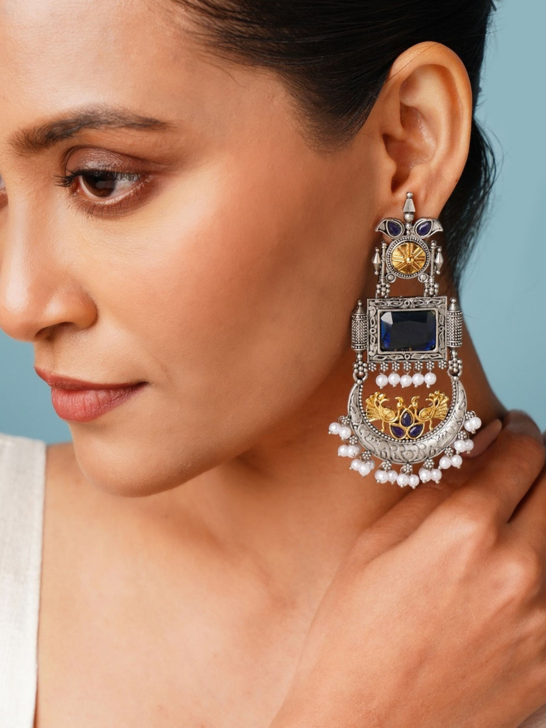 Close-up of woman wearing Abdesignsjewellery German Silver Dual Tone Peacock Earrings with intricate design and pearl accents