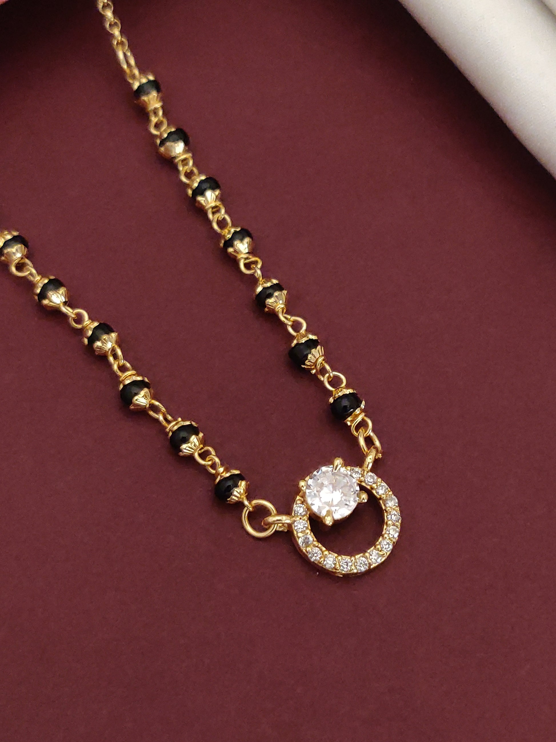 Elegant Gold Plated American Diamond Mangalsutra with a sparkling centerpiece and black beaded chain