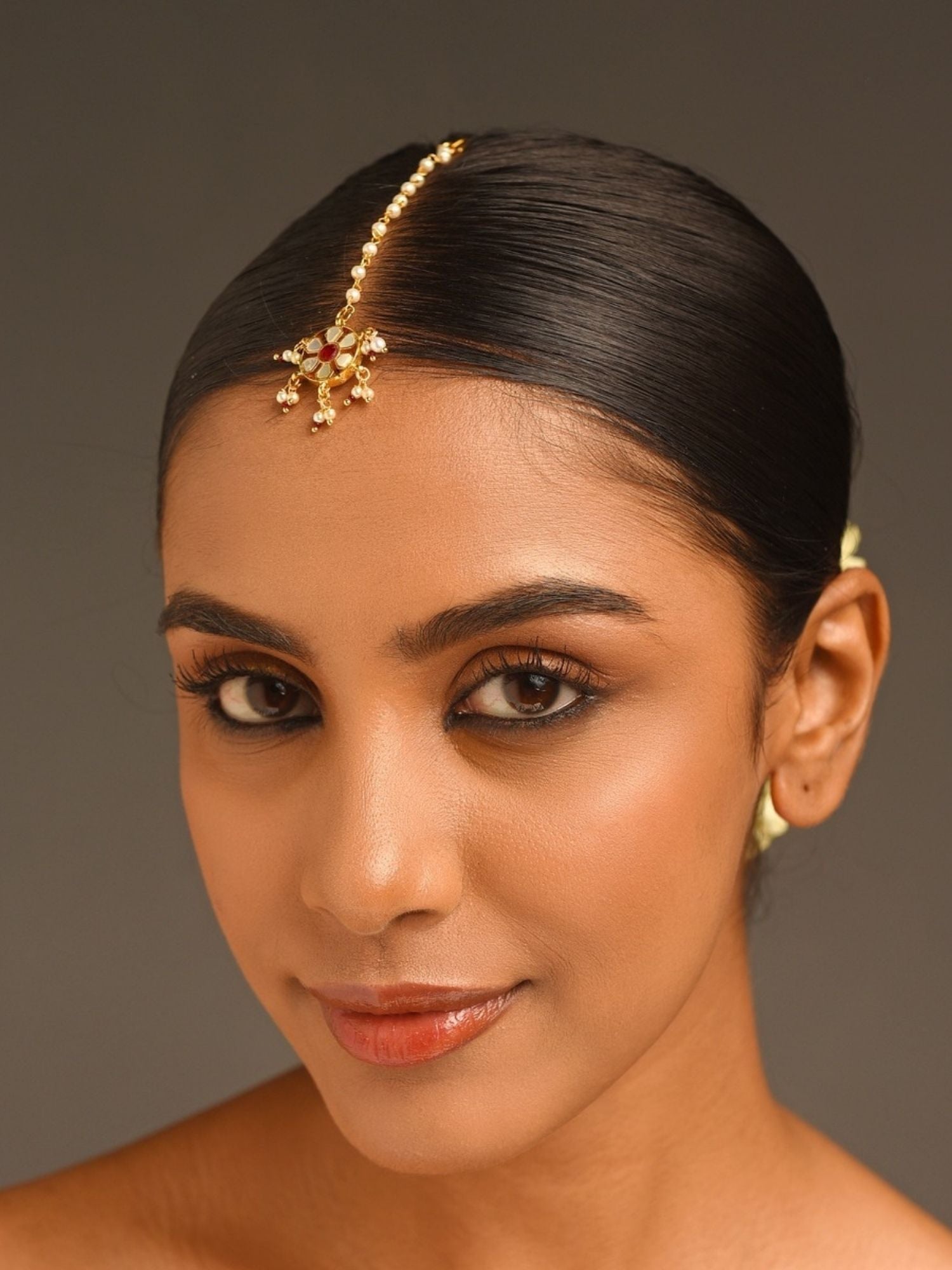 Gold Plated Colourful Paachi Kundan Maangtikka worn by woman with sleek hair and warm makeup