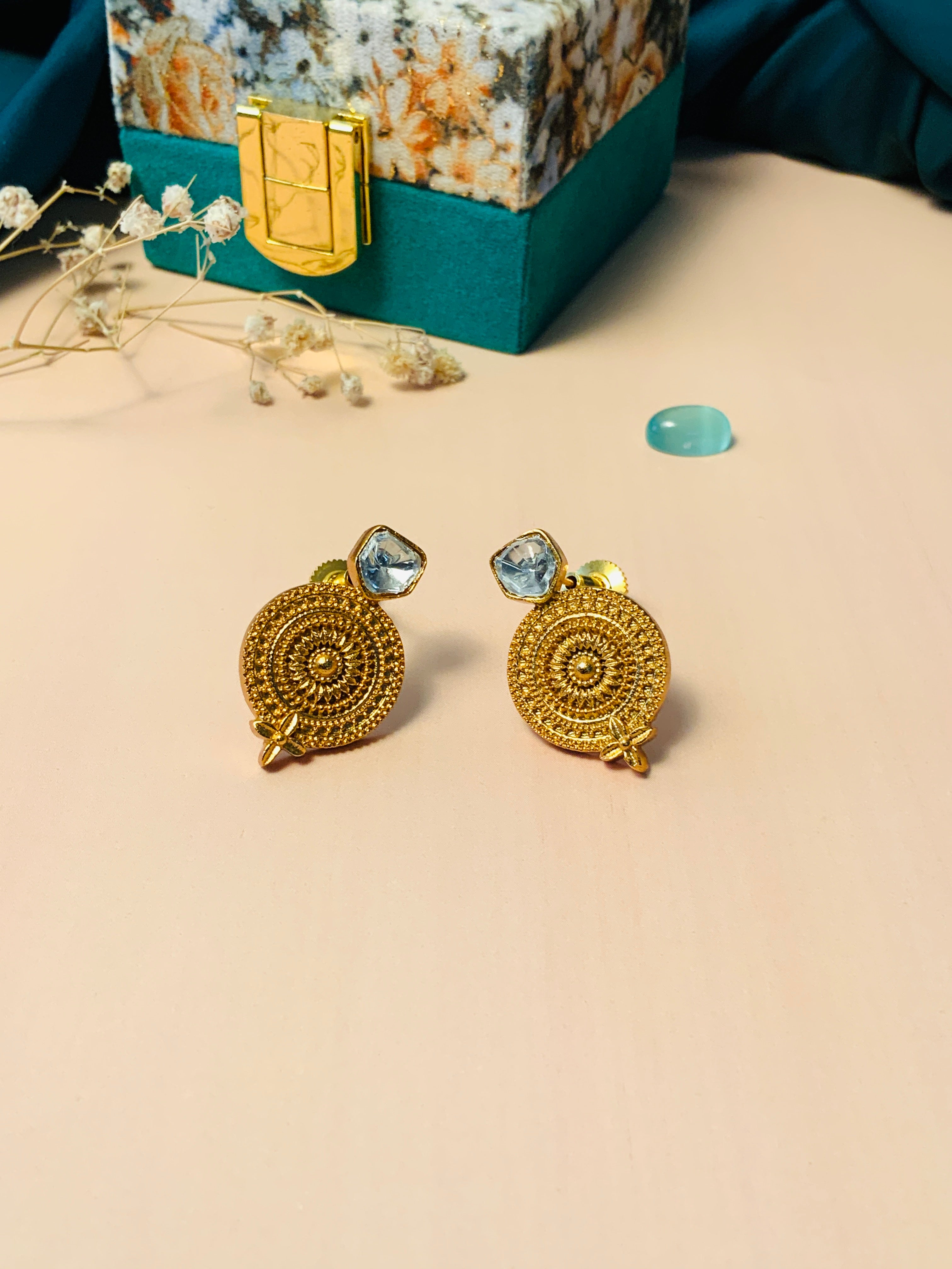 Gold Plated Glass Kundan Polki Stud Earrings with intricate circular design displayed on beige surface