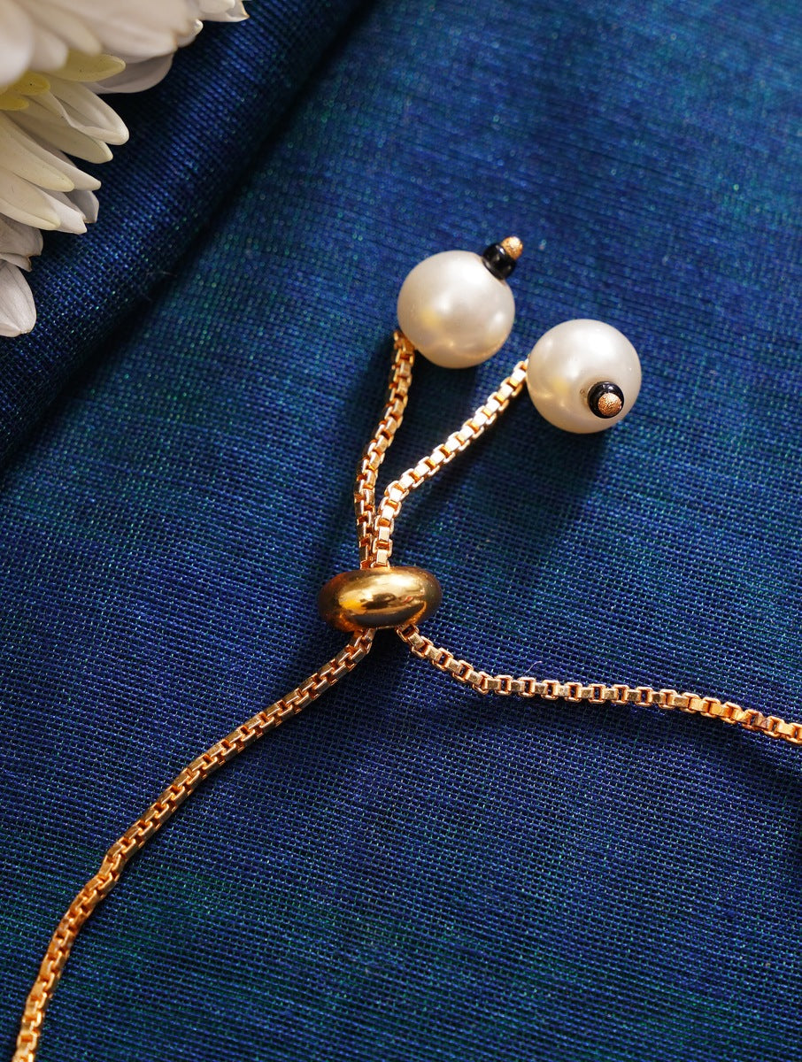 Close-up of gold chain with pearl beads on blue fabric showcasing Gold Plated Hand Mangalsutra by Abdesignsjewellery