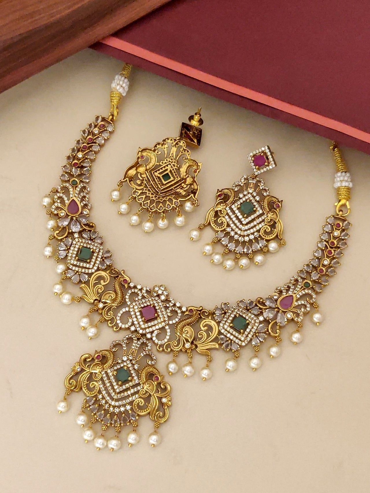 Gold plated multicolour diamond necklace set featuring intricate designs and pearl embellishments
