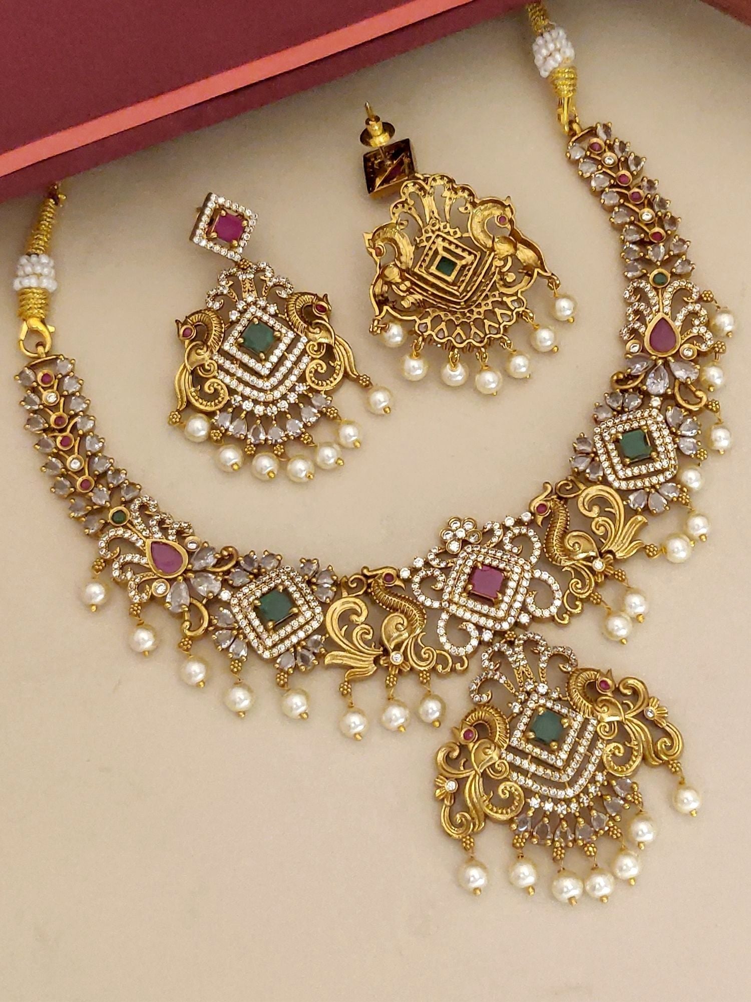 Gold plated multicolour diamond necklace set with matching earrings featuring intricate designs
