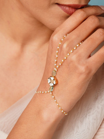 Gold Plated Polki Hand Bracelet with pearls and gemstones worn on hand by woman