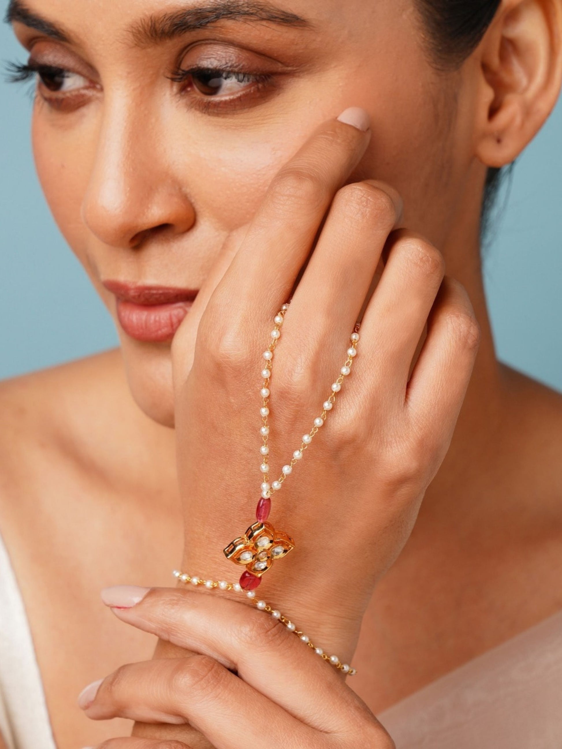 Gold Plated Polki Hand Bracelet by Abdesignsjewellery worn on model hand with pearl and red gemstone details