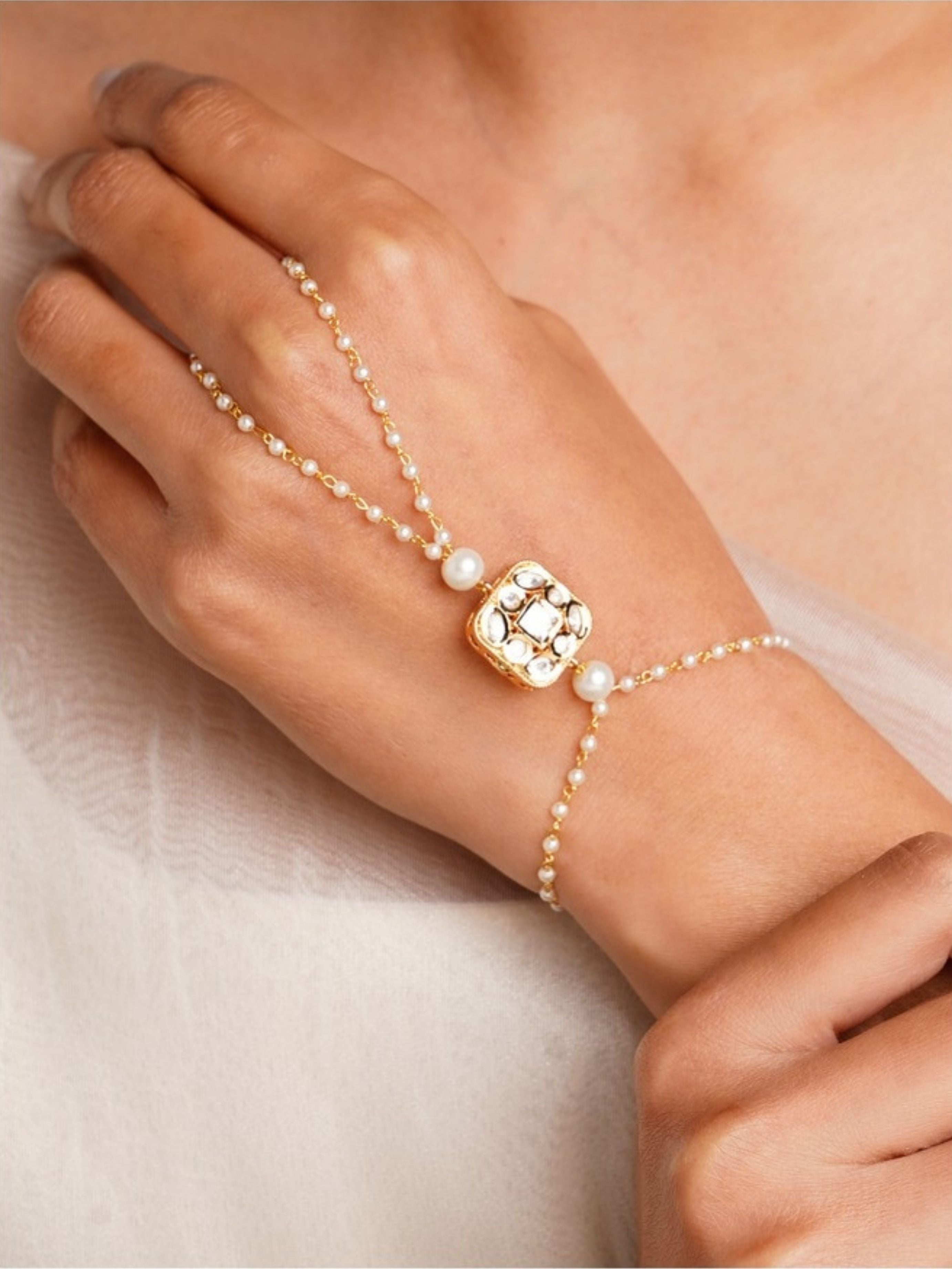 Gold Plated Polki Hand Bracelet with pearls and intricate design worn on hand by Abdesignsjewellery