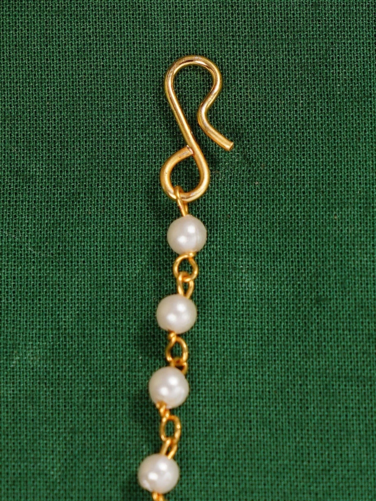 Gold Plated Polki Paachi Kundan Maangtikka with pearl accents and hook clasp on green fabric
