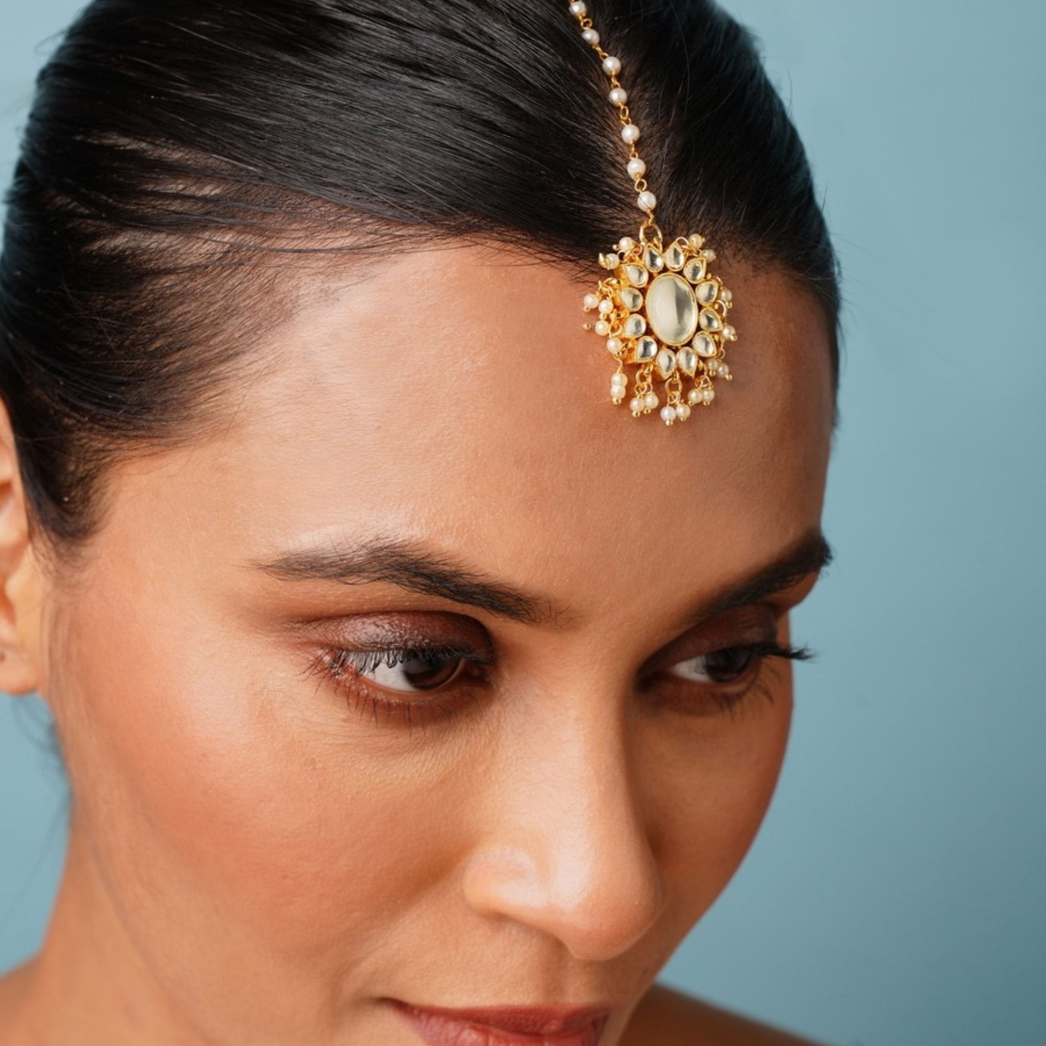 Gold Plated Polki Paachi Kundan Maangtikka worn on forehead by woman with sleek hair