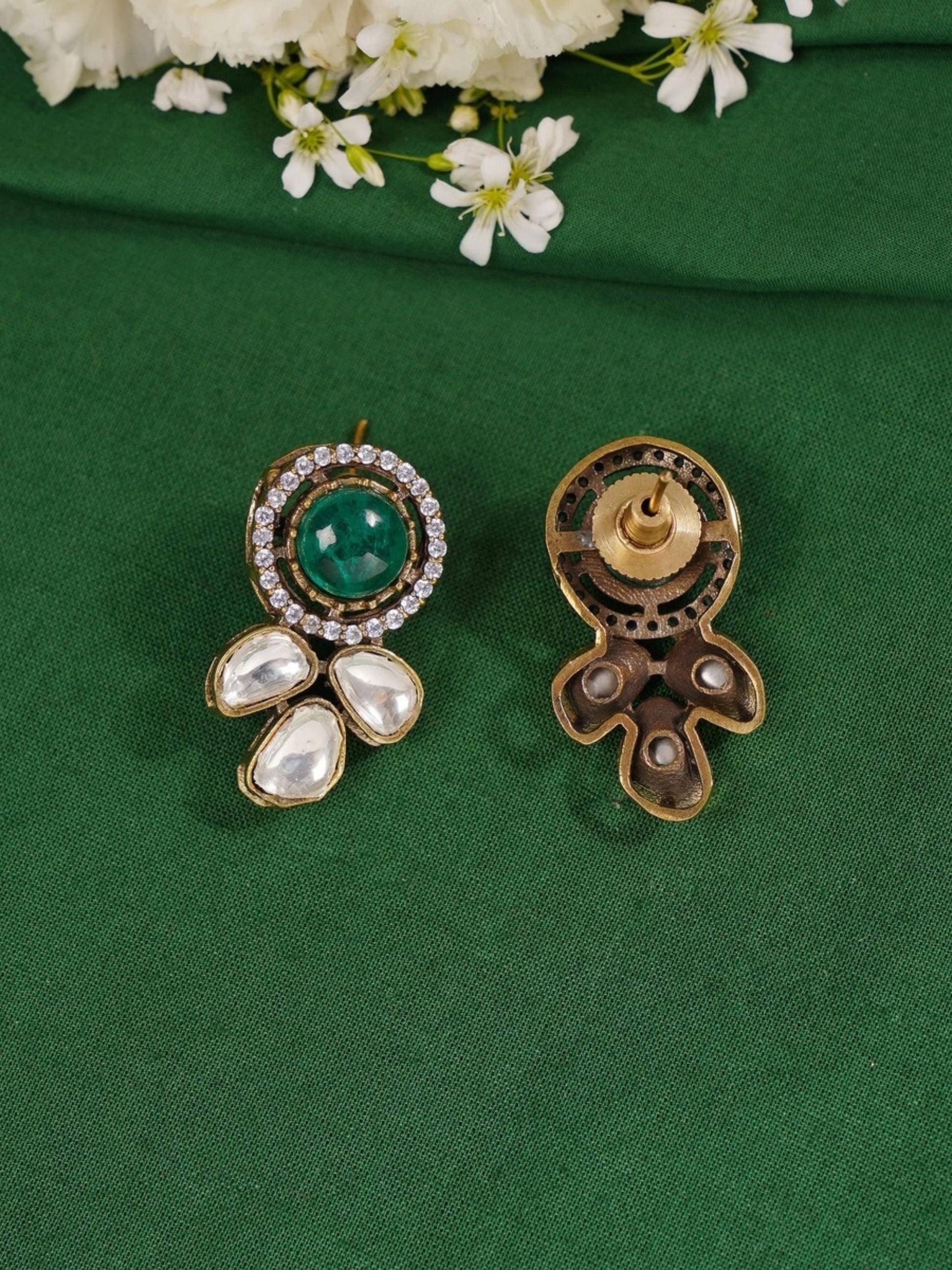 Green Emerald Statement Oxidsed Gold Polki Necklace Set pendant earrings with intricate design on green fabric