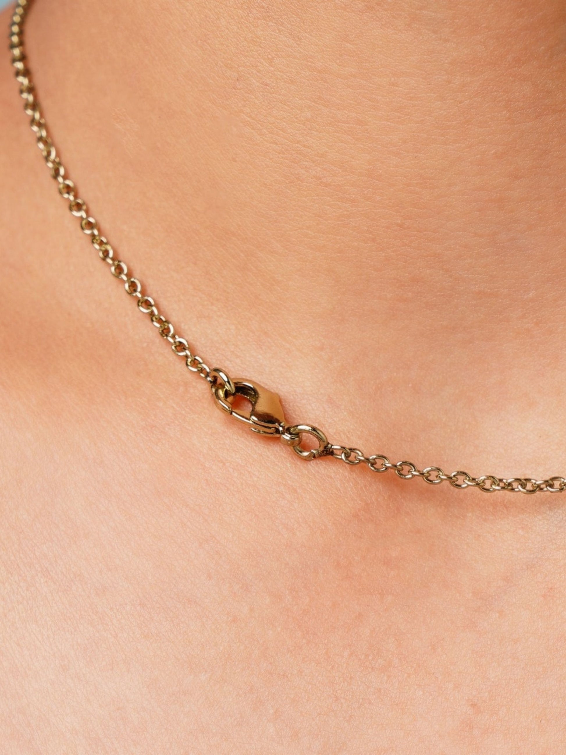 Close-up of a gold pendant chain clasp worn on the neck by Abdesignsjewellery featuring Green Emerald Statement Oxidsed Gold Polki Necklace Set