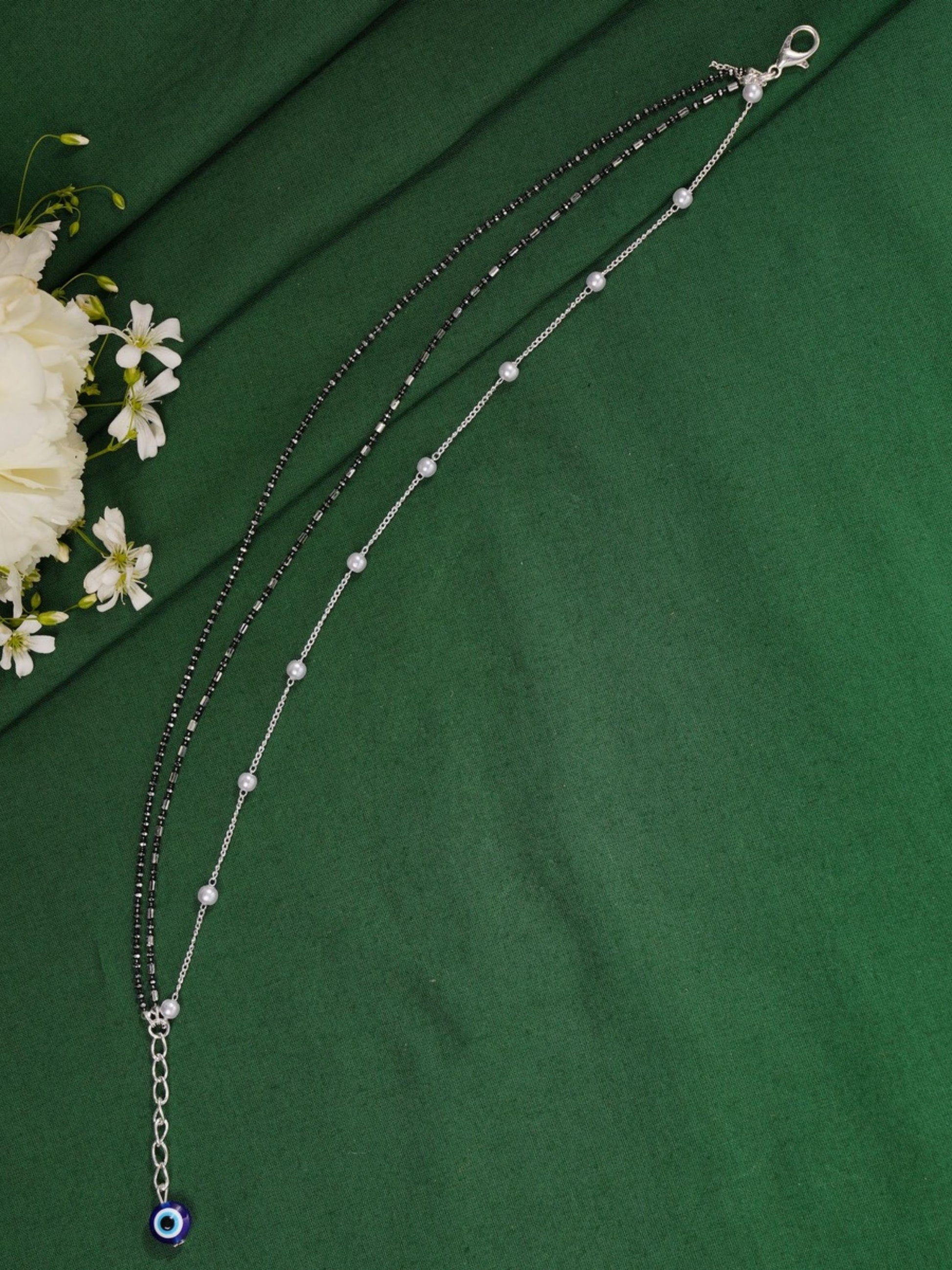 Handcrafted Silver Evil Eye Foot Jewelry Anklet combo with black beads and silver chain on green fabric