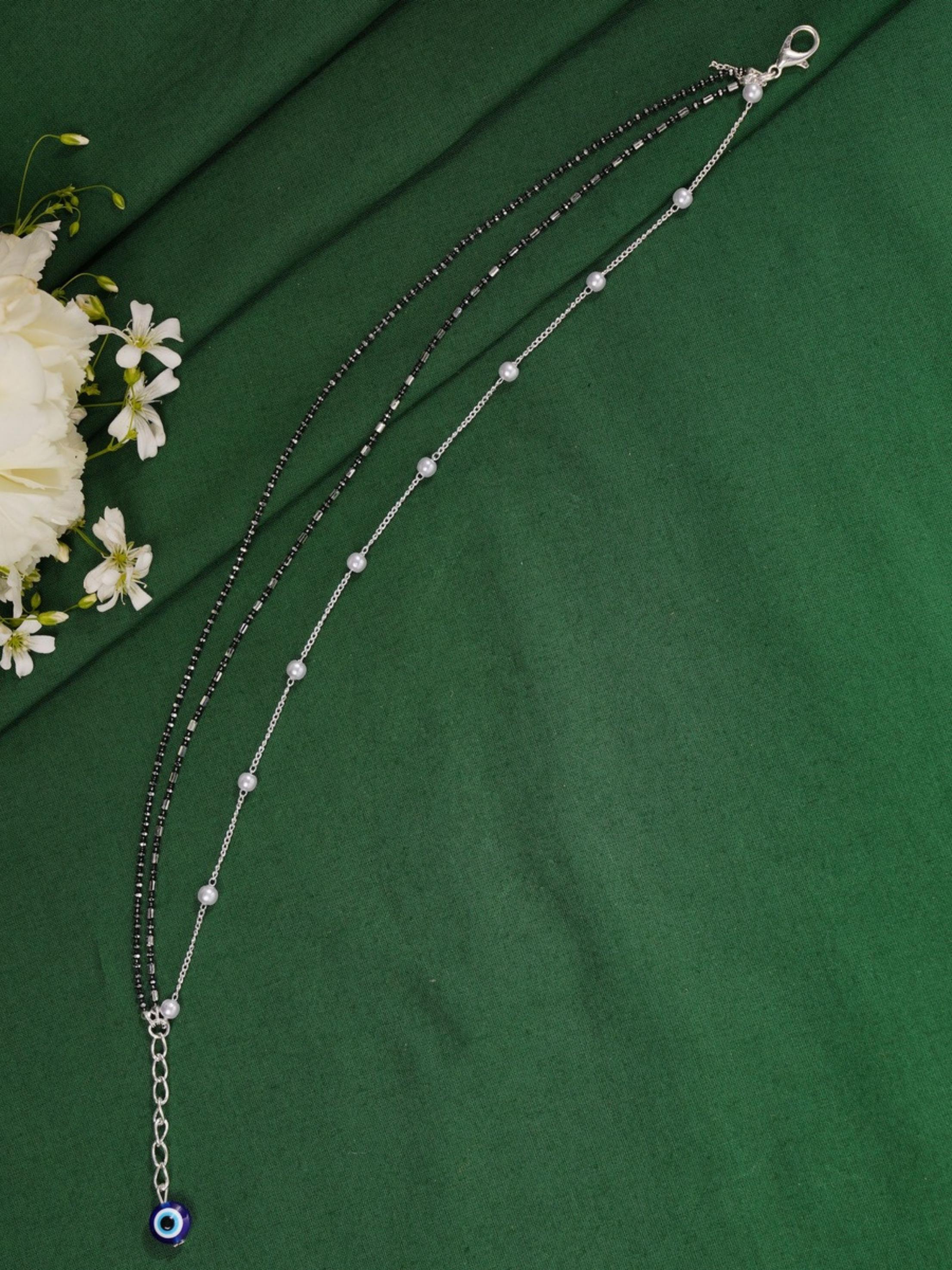 Handcrafted Silver Evil Eye Foot Jewelry Anklet combo with black beads and silver chain on green fabric