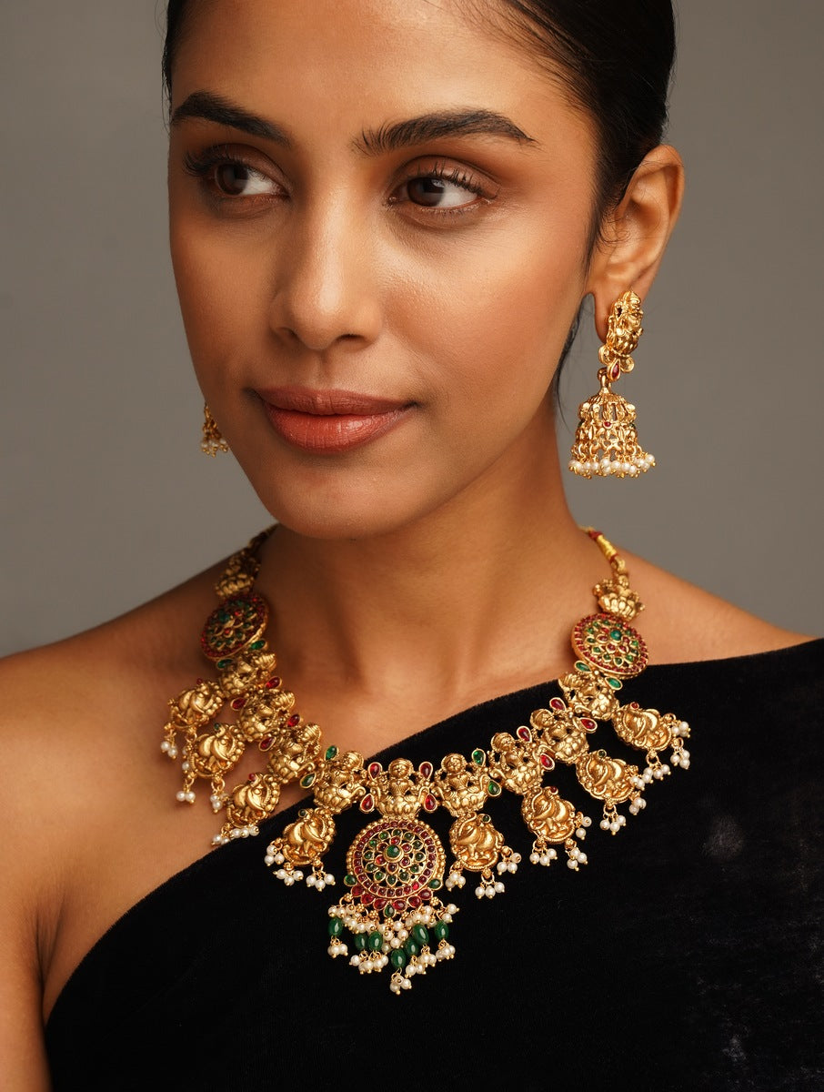 Woman wearing Antique Matt Gold Plated Temple Necklace Set with intricate traditional design and matching earrings