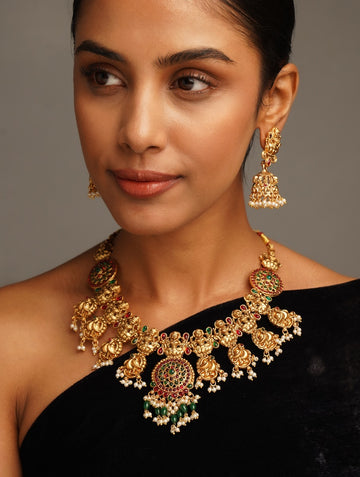 Woman wearing Antique Matt Gold Plated Temple Necklace Set with intricate traditional design and matching earrings
