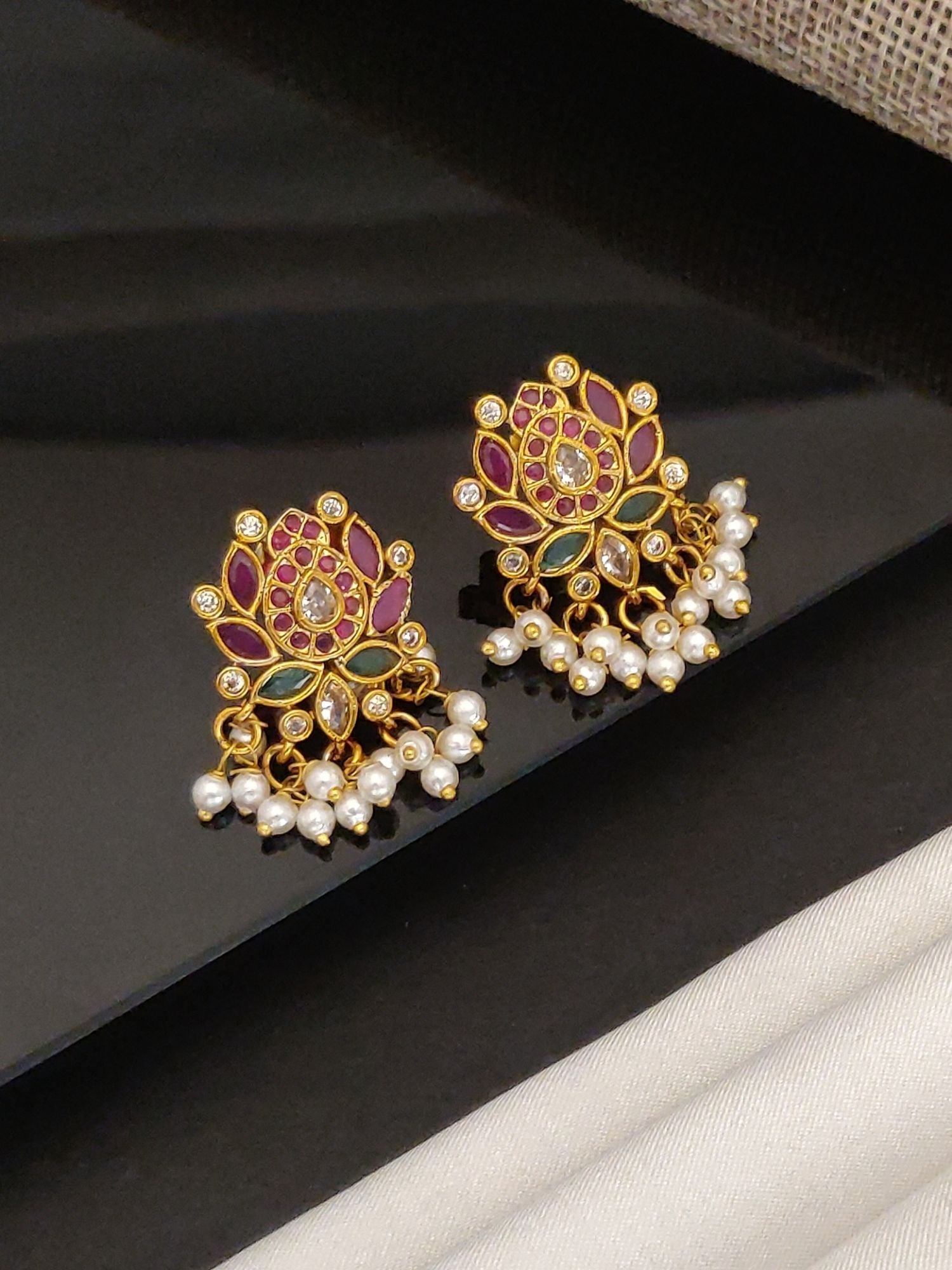Artificial Floral gold jhumka earrings for women with purple and green enamel and pearl accents