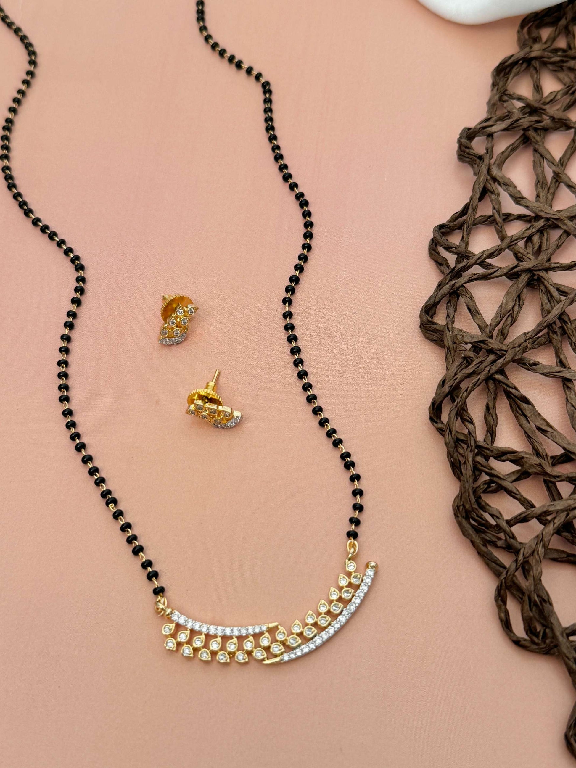 Elegant Gold Plated American Diamond Mangalsutra Set with matching stud earrings on a beige background