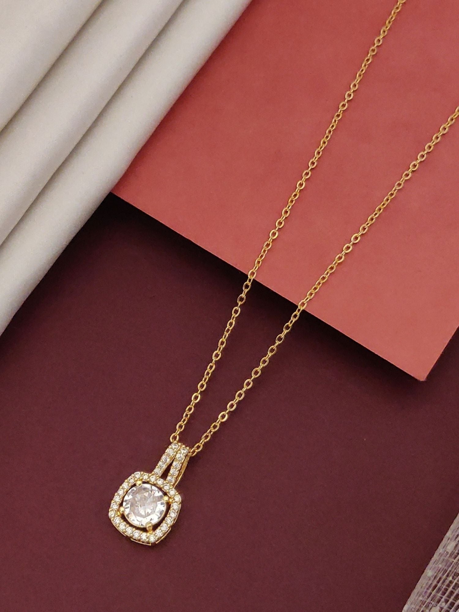 Elegant gold plated pendant necklace featuring a sparkling central stone and intricate detailing