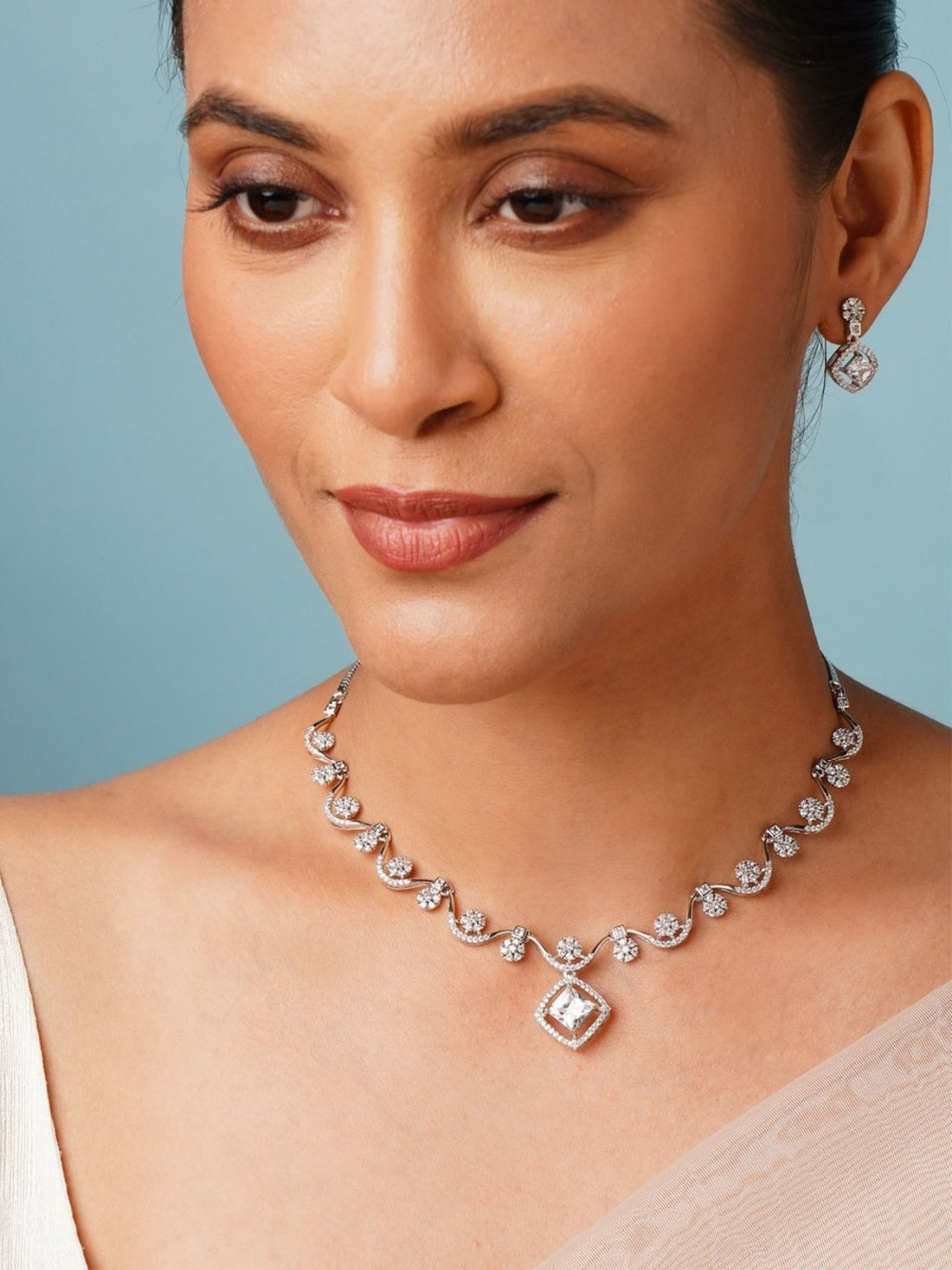 Elegant Necklace with Sparkling Stones by Abdesignsjewellery worn by a woman with matching earrings