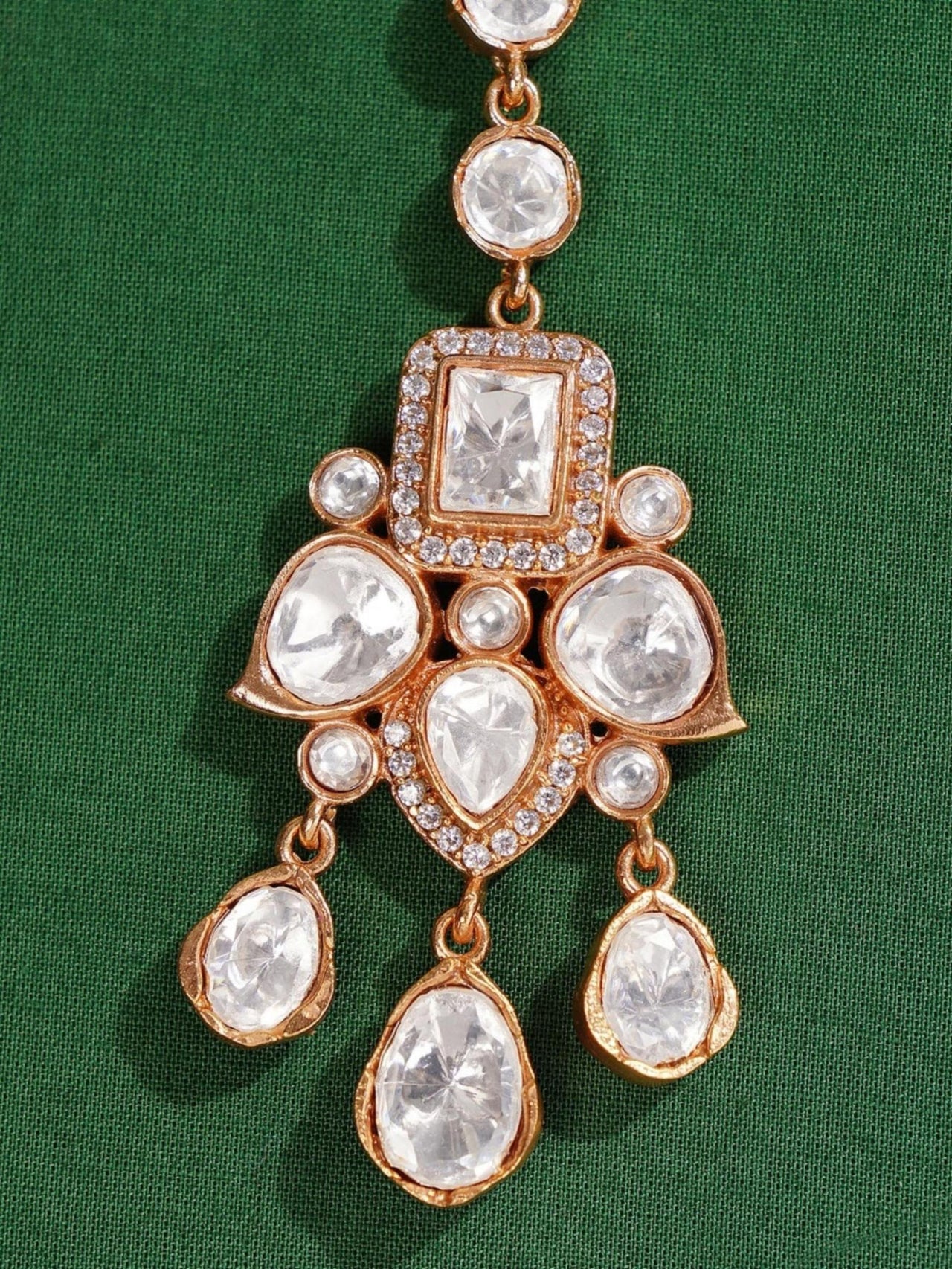 Elegant Polki Paachi Kundan Maangtikka with intricate white stones set in gold tone on green background