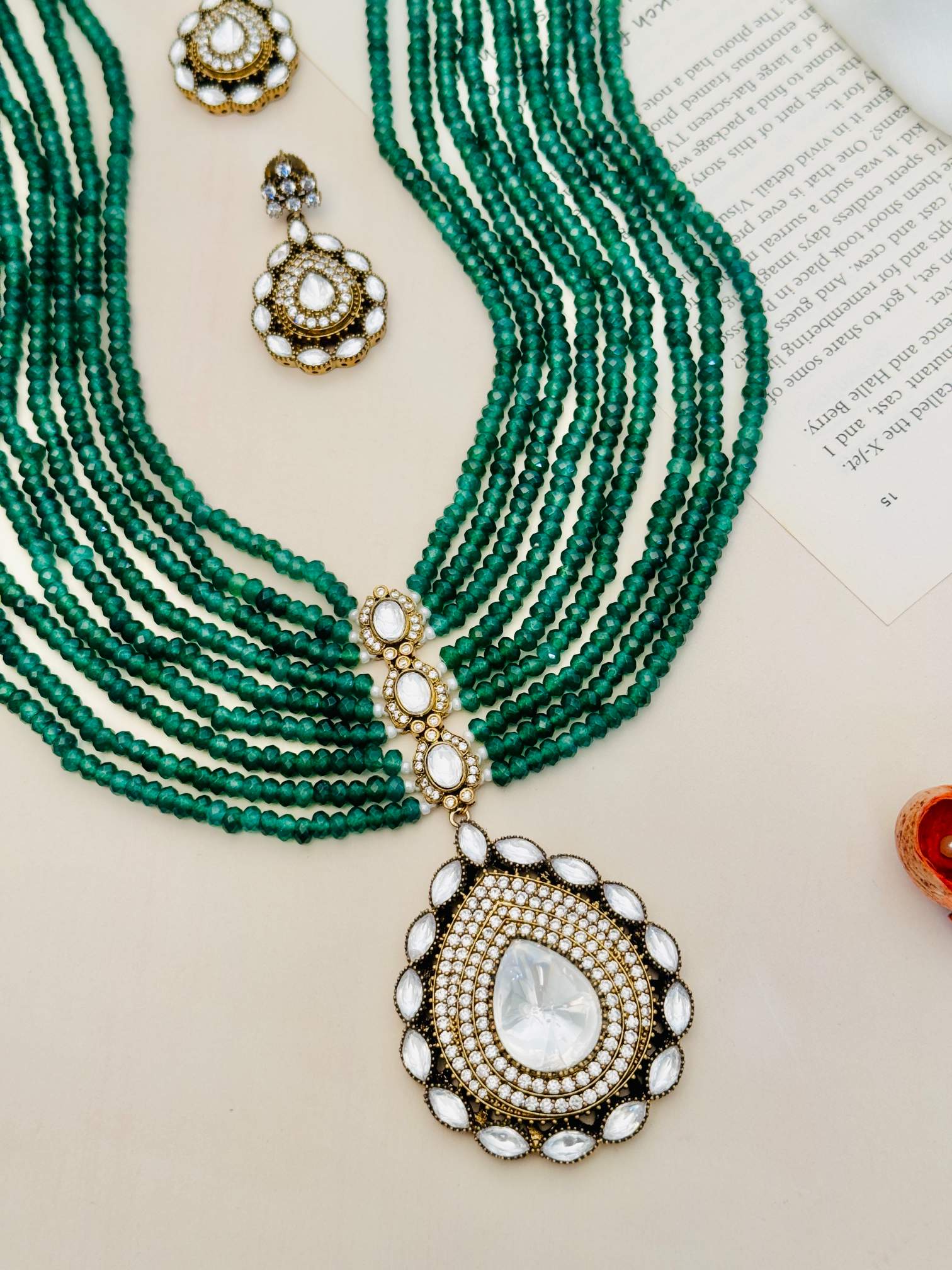 Emerald Green Polki Jaipuri Mala Set with multi-strand green beads and intricate white stone pendant and matching earrings