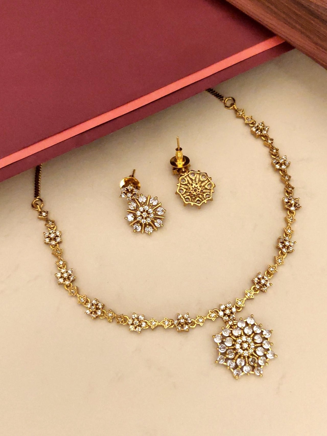 Extravagant Gold Plated American Diamond Necklace Set with floral design and matching earrings