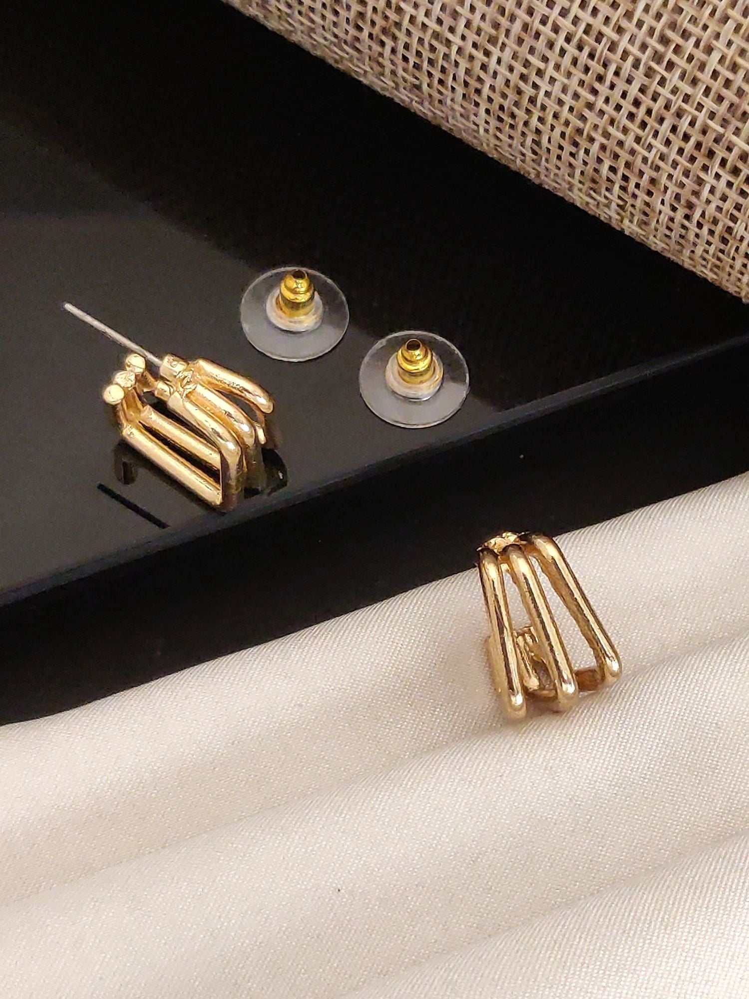 Abdesignsjewellery Fancy Gold Plated Western Studs Earring modern triple bar gold stud pair with clear push backs on fabric