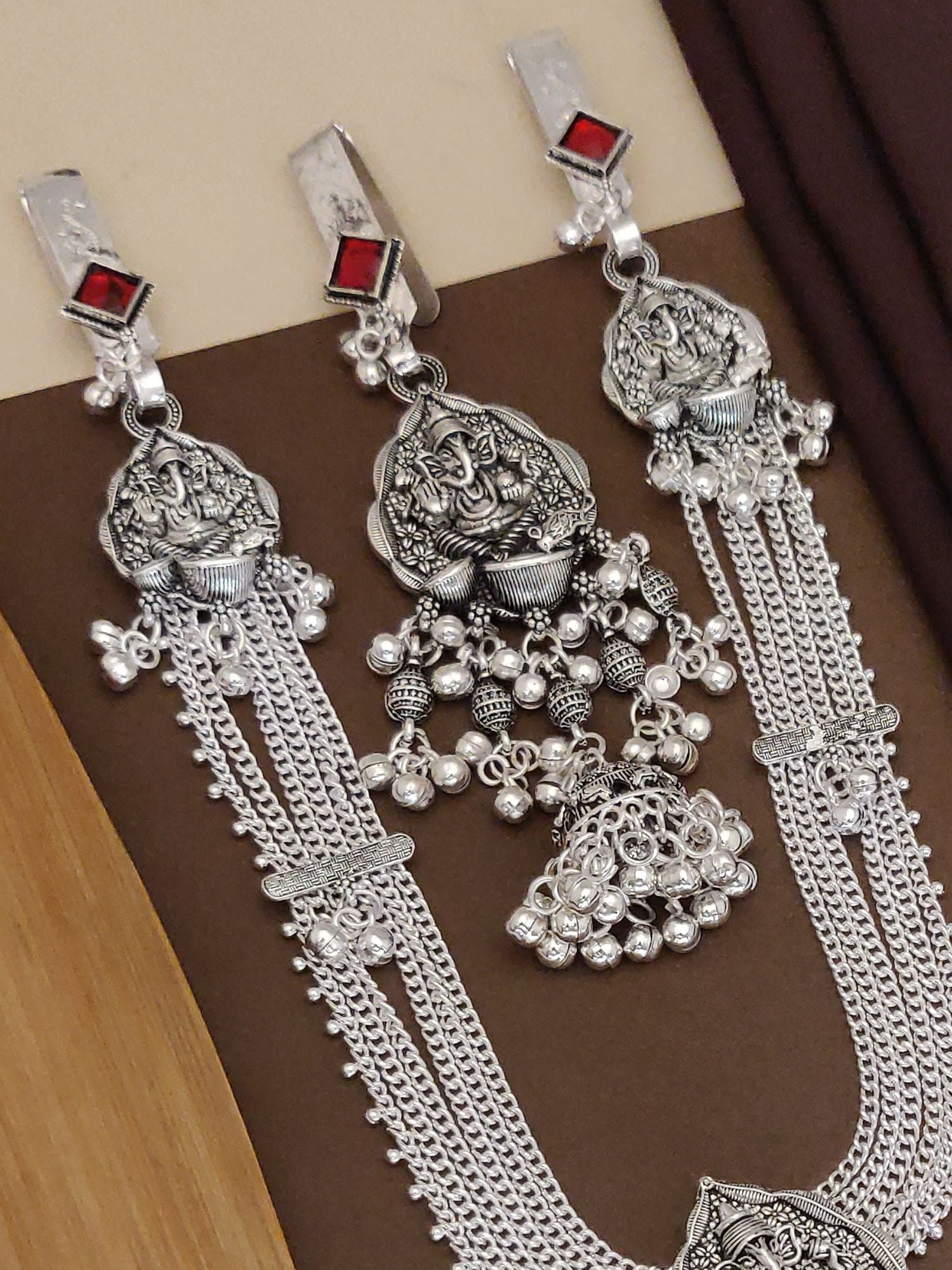 Ganesh style Juda pin set featuring intricate silver design and red accents for traditional elegance