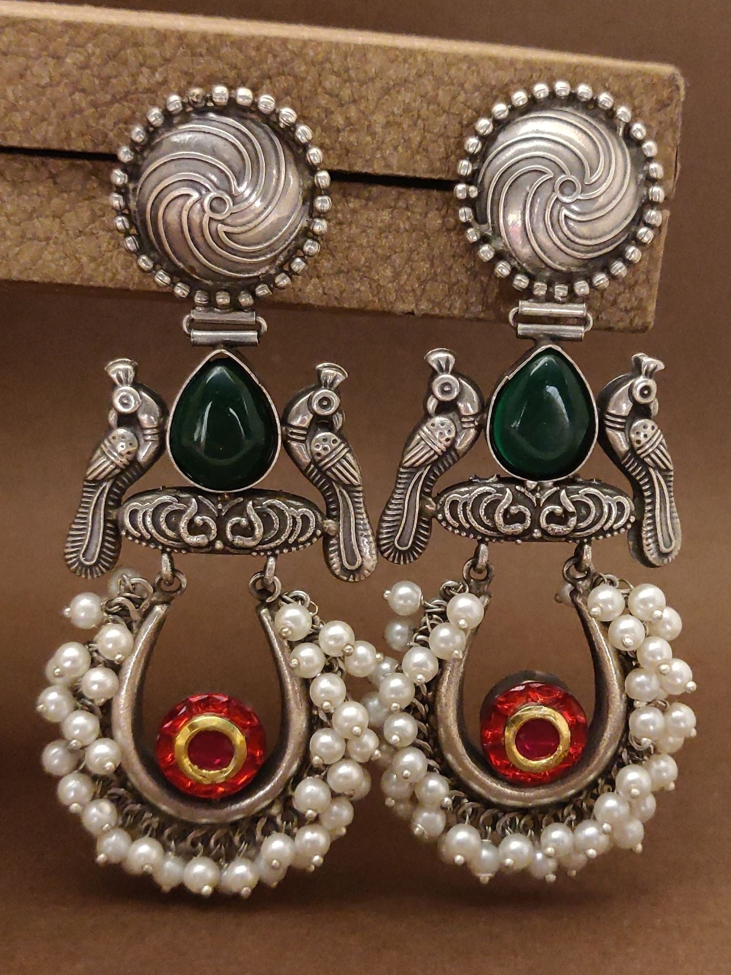 German silver chaandbali earrings featuring intricate bird designs and colorful stones