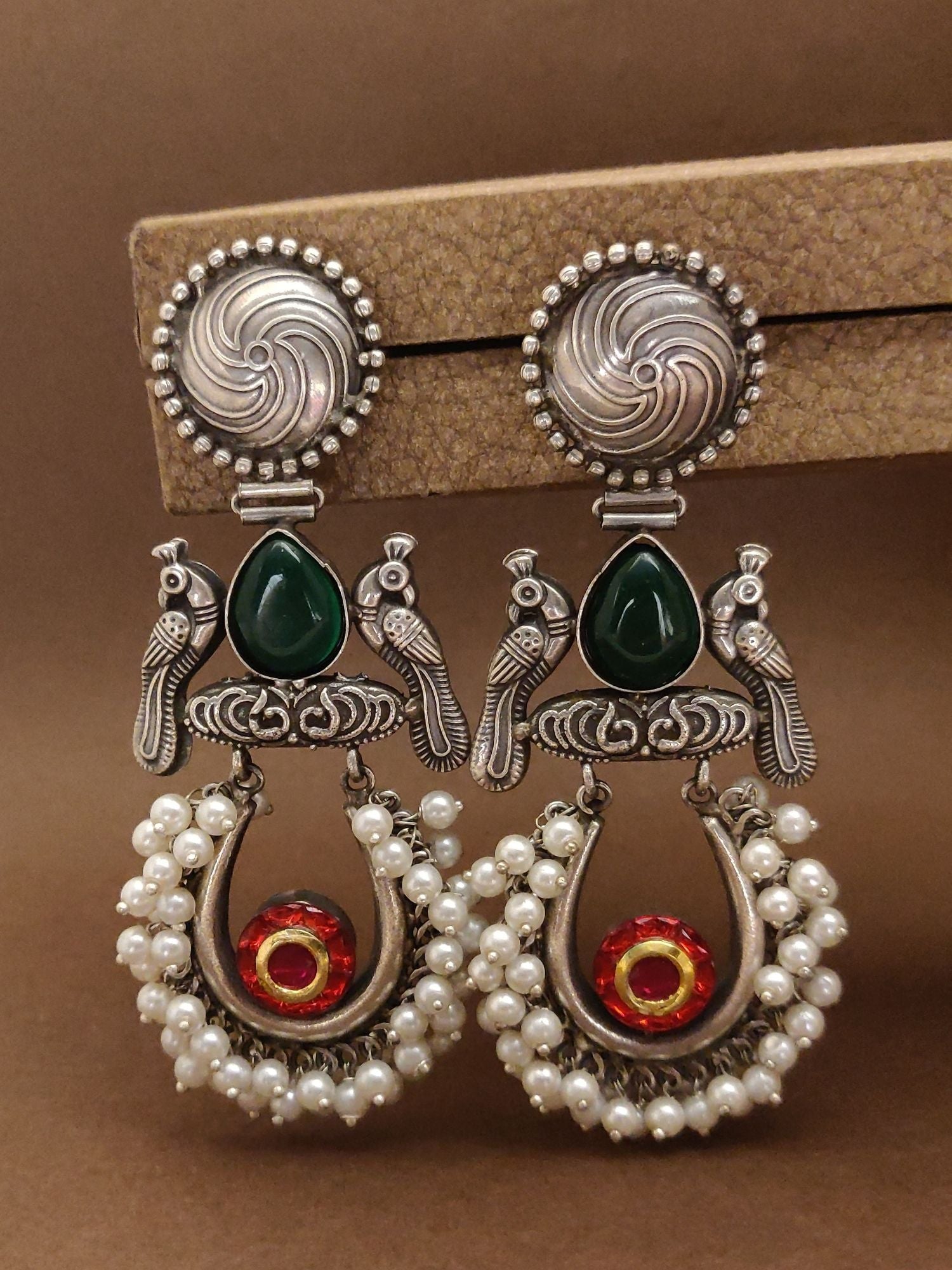 Exquisite German silver chaandbali earrings featuring green stones and pearl accents