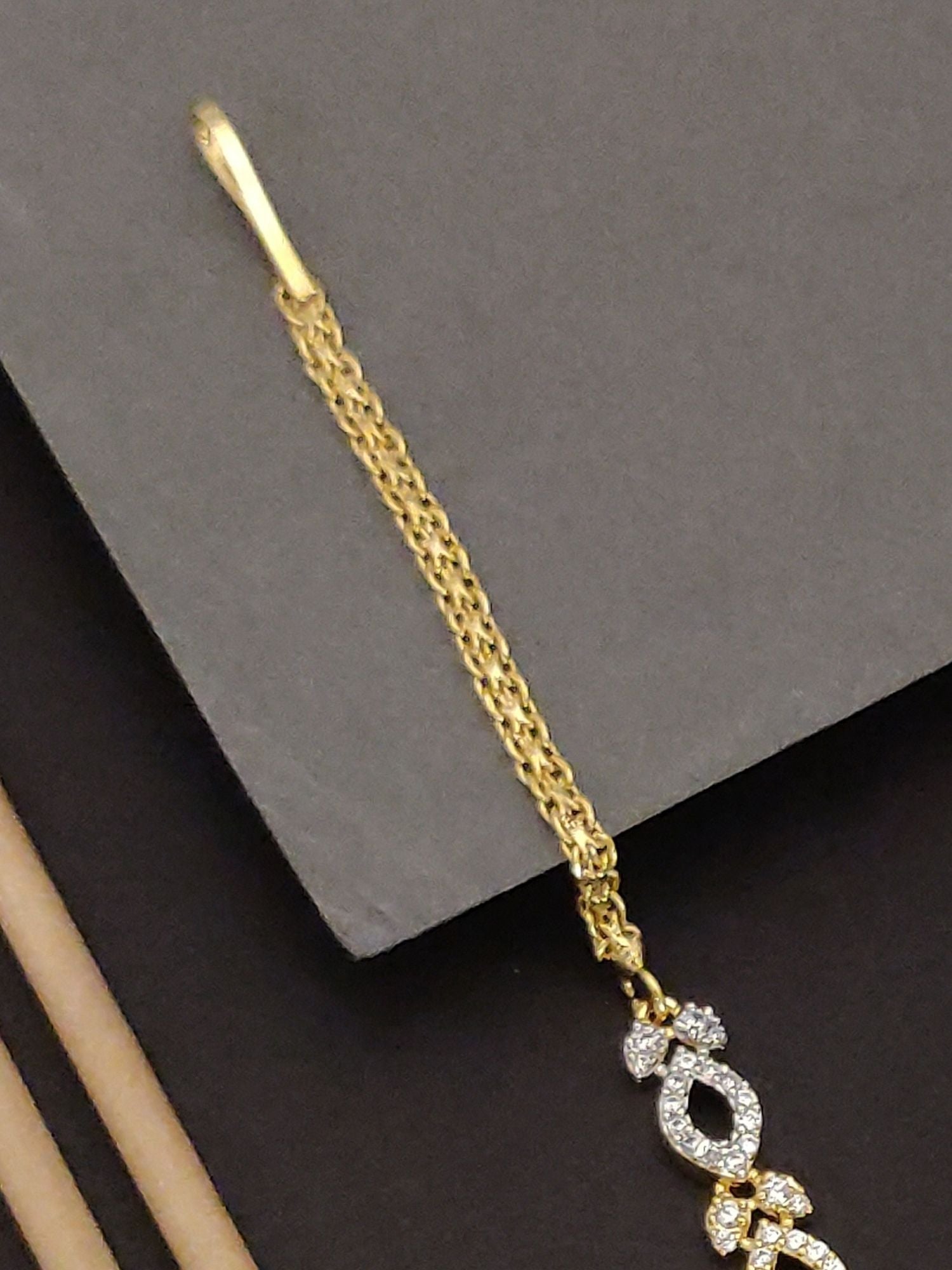 Gold Plated American Diamond Maangtikka with intricate design for elegant traditional wear
