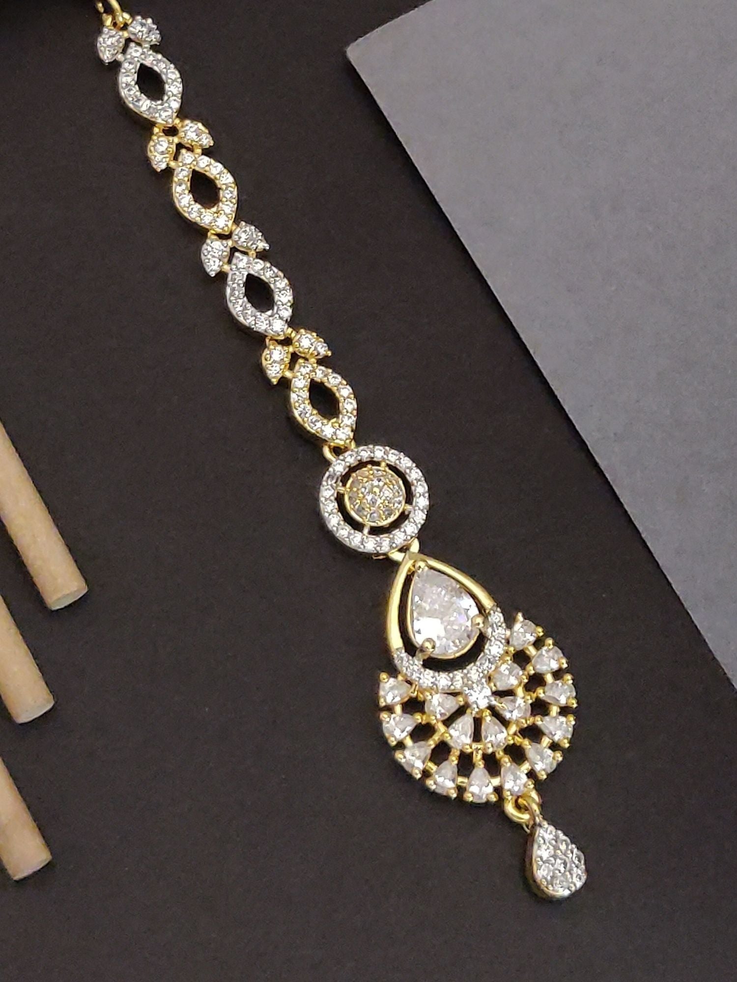 Gold Plated American Diamond Maangtikka with intricate design and sparkling stones for traditional elegance