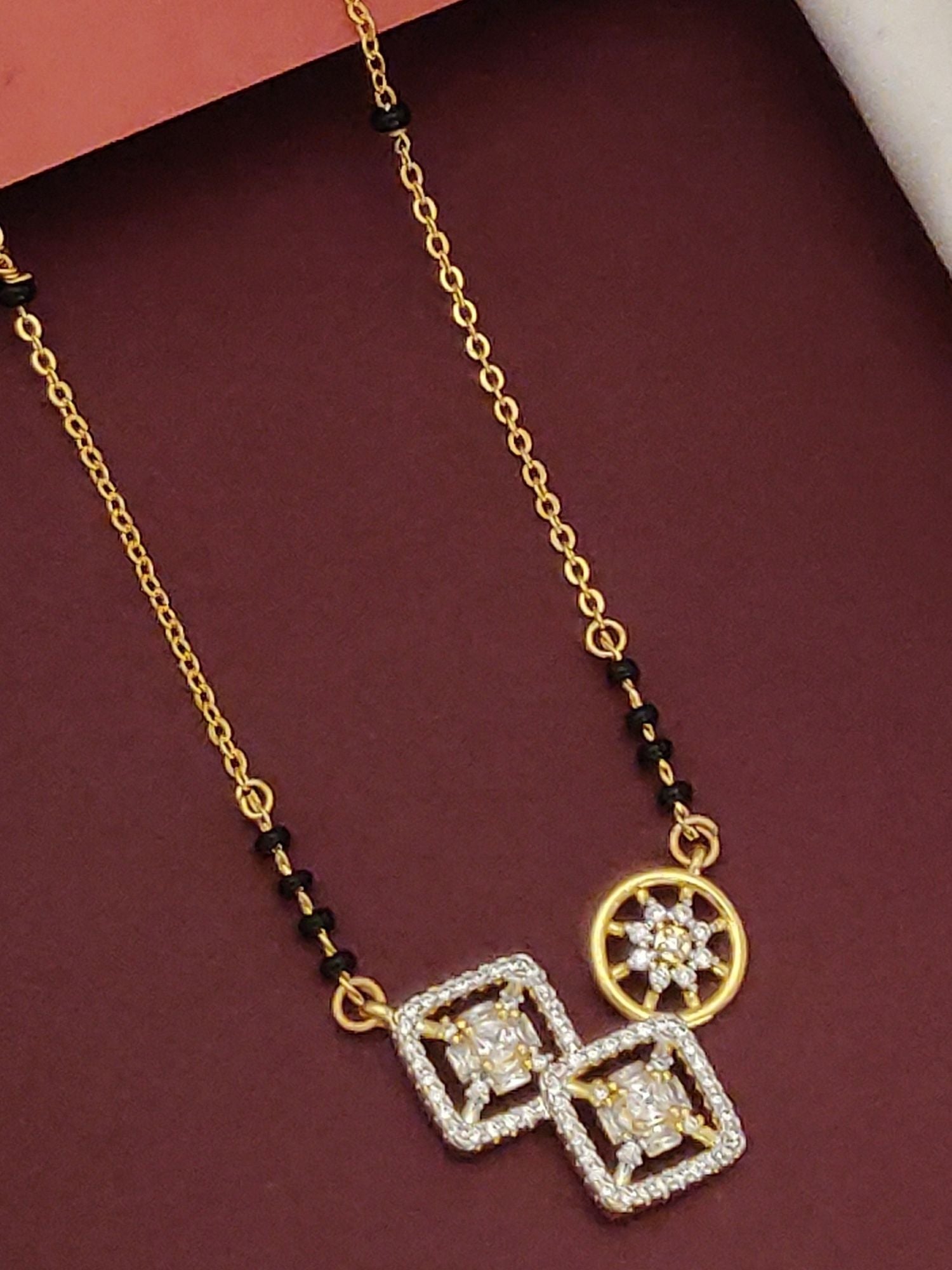 Gold Plated American Diamond Mangalsutra with intricate square and circular pendant design on black-beaded chain