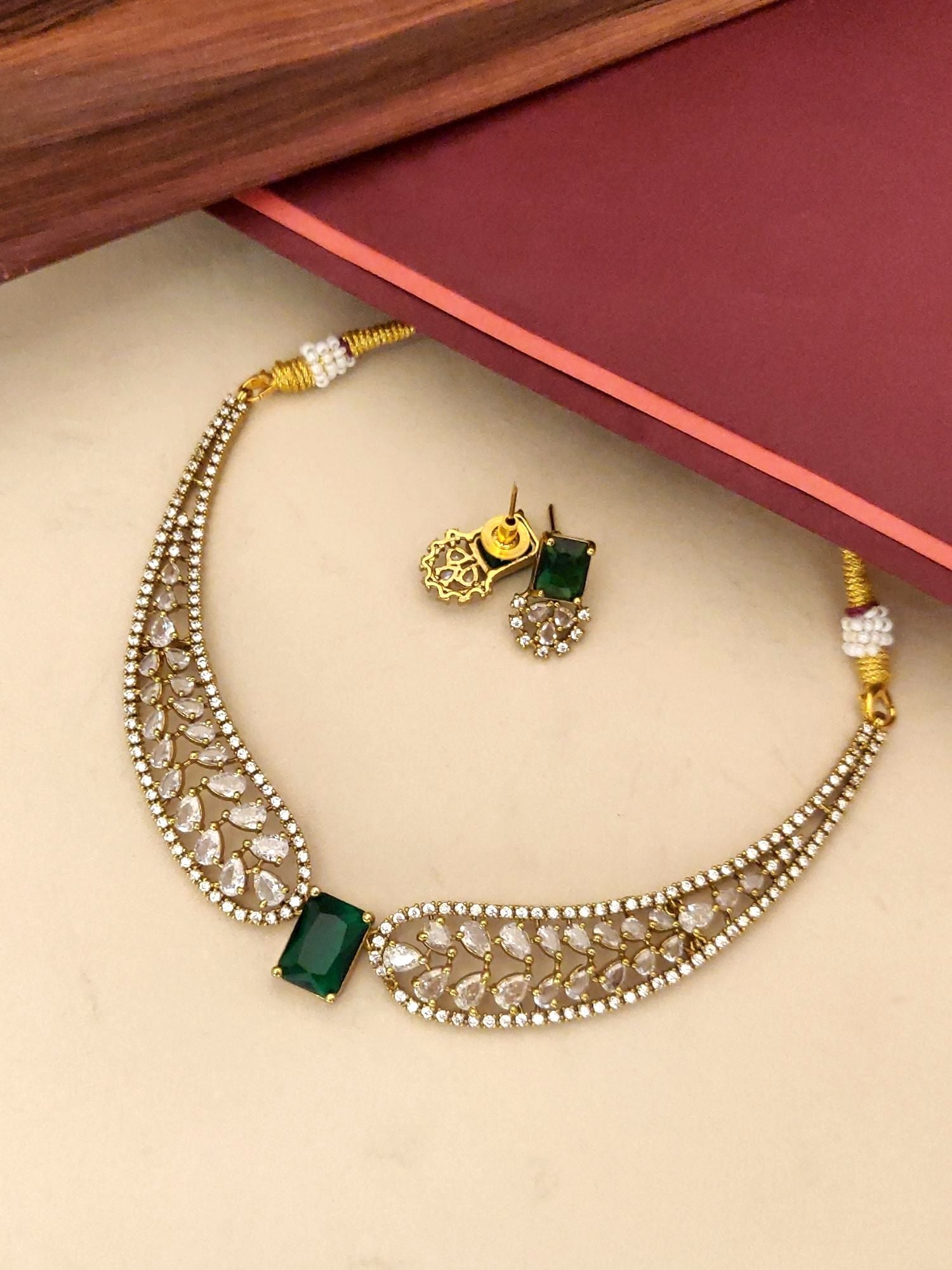 Gold plated choker necklace set with green gemstone and intricate design, complemented by matching earrings