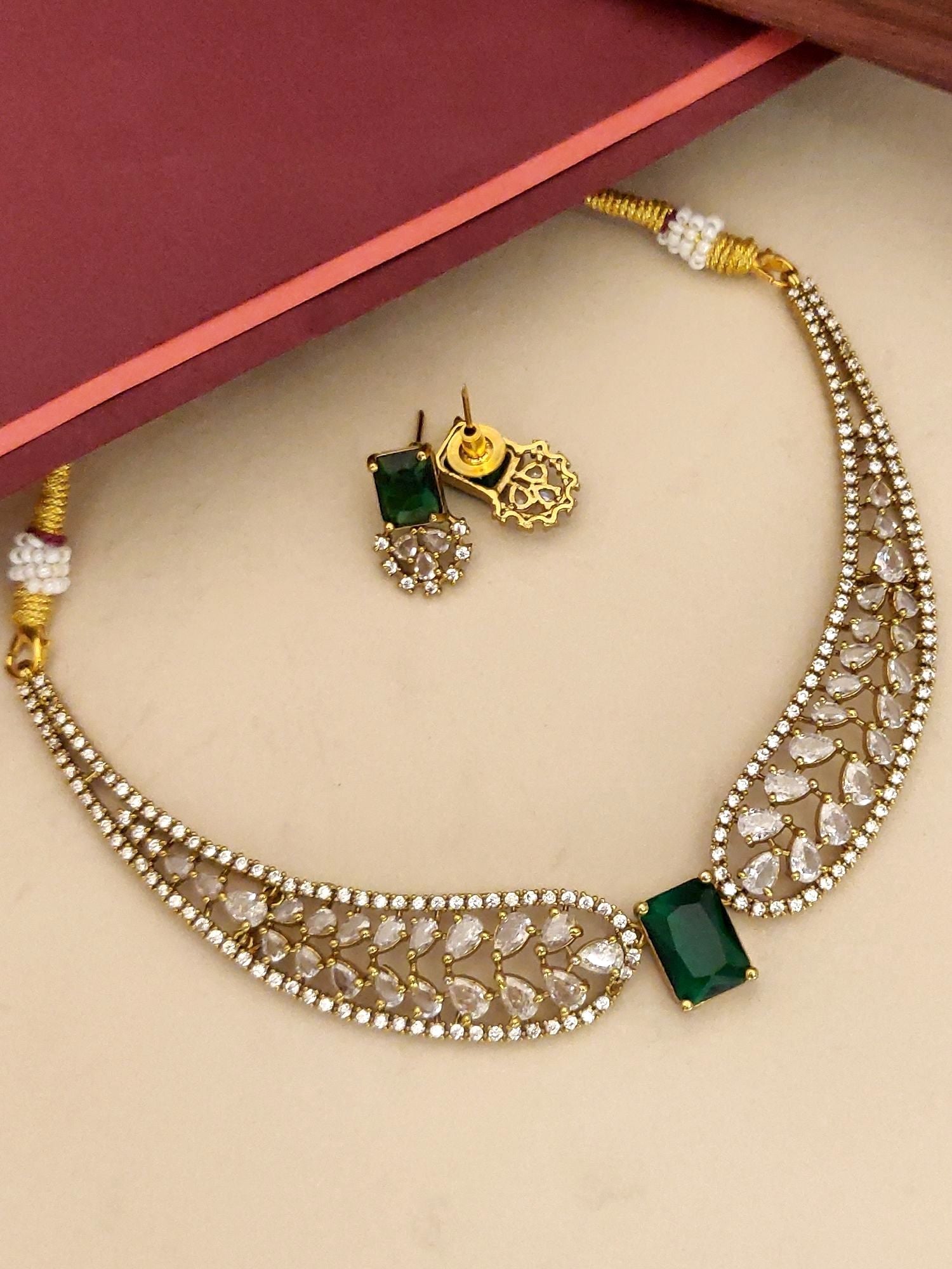 Gold plated choker necklace set with green stones and intricate design, includes matching earrings