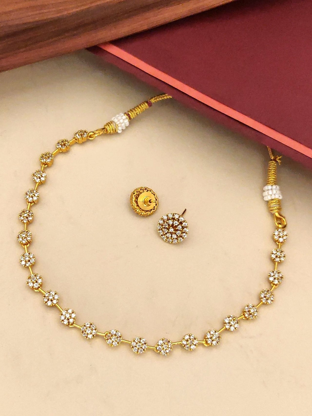 Gold plated diamond necklace set with intricate floral design and matching earrings