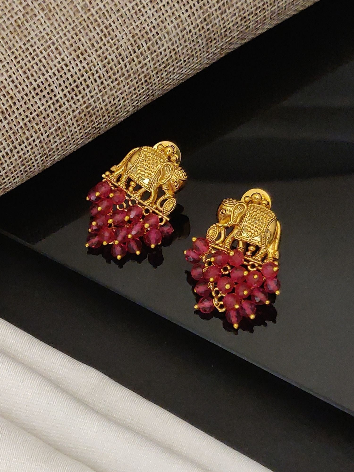 Gold plated elephant earrings with intricate designs and red bead accents by Abdesignsjewellery