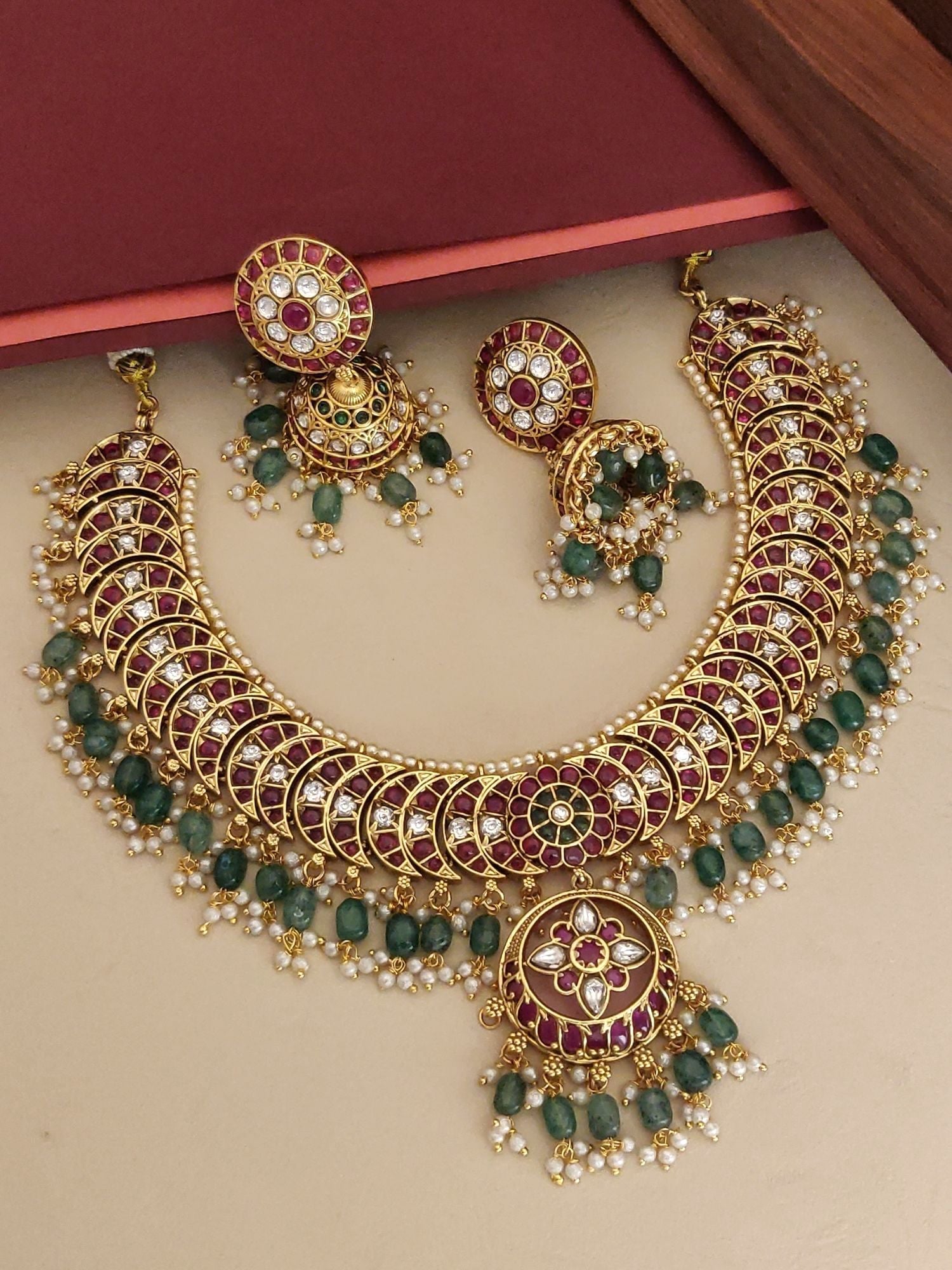 Gold plated kempstone necklace set with intricate designs and matching earrings adorned with pearls