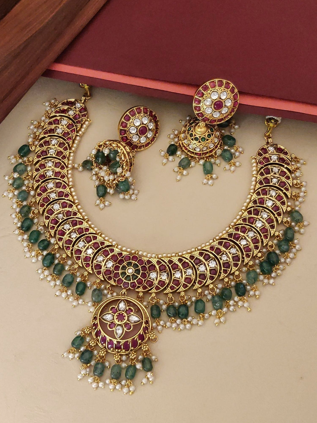 Gold plated kempstone necklace set with intricate designs and matching earrings adorned with pearls