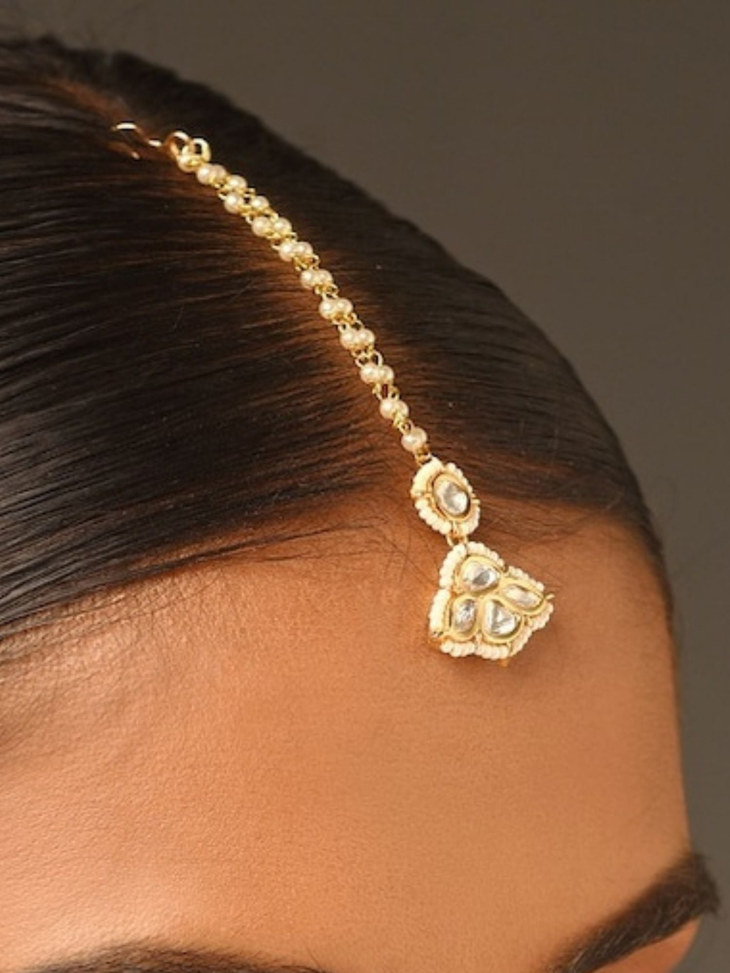 Gold Plated Kundan Maangtikka with intricate stone detailing worn on forehead