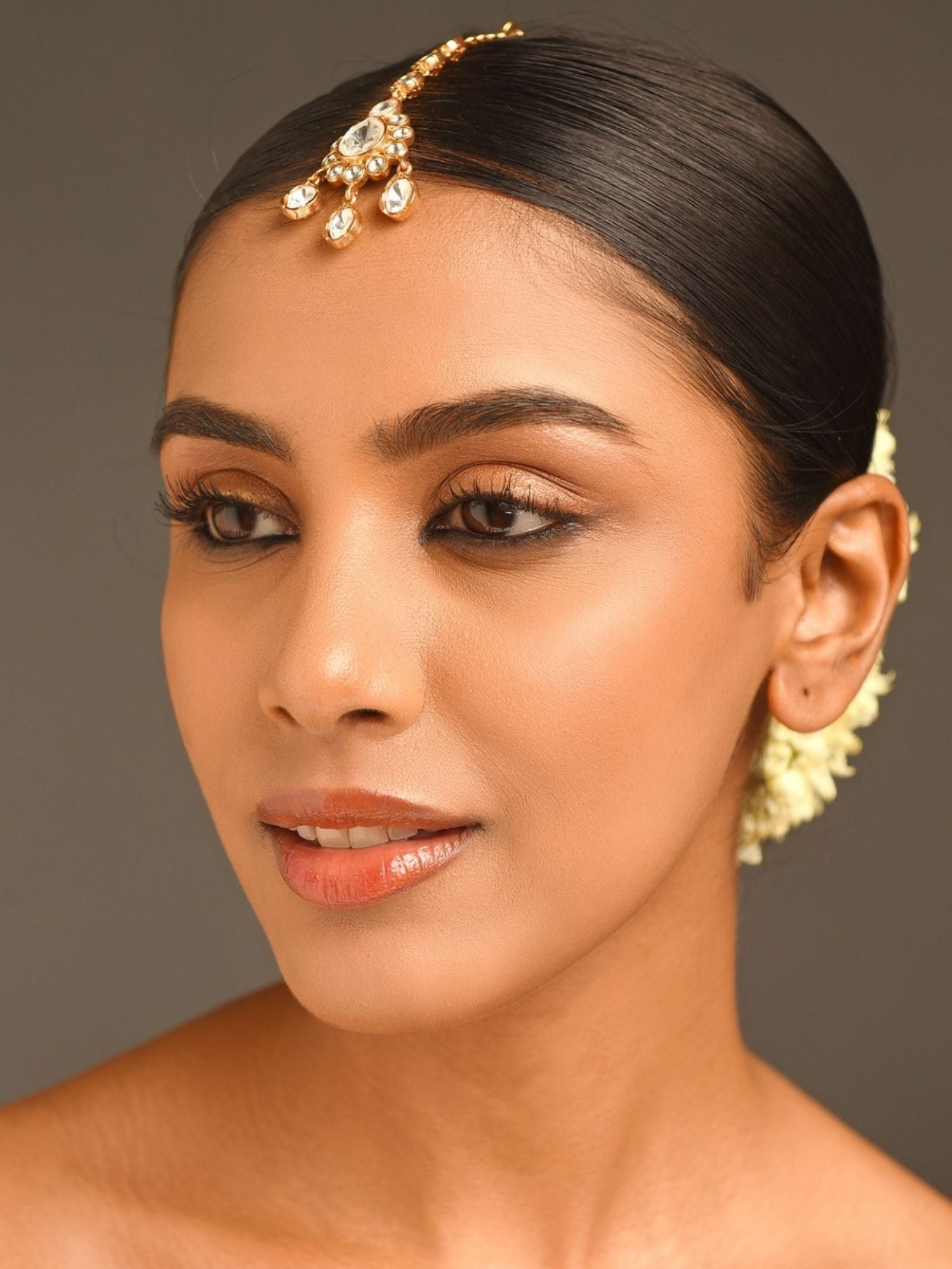 Gold Plated Polki Maangtikka worn by a woman with sleek hair and natural makeup by Abdesignsjewellery