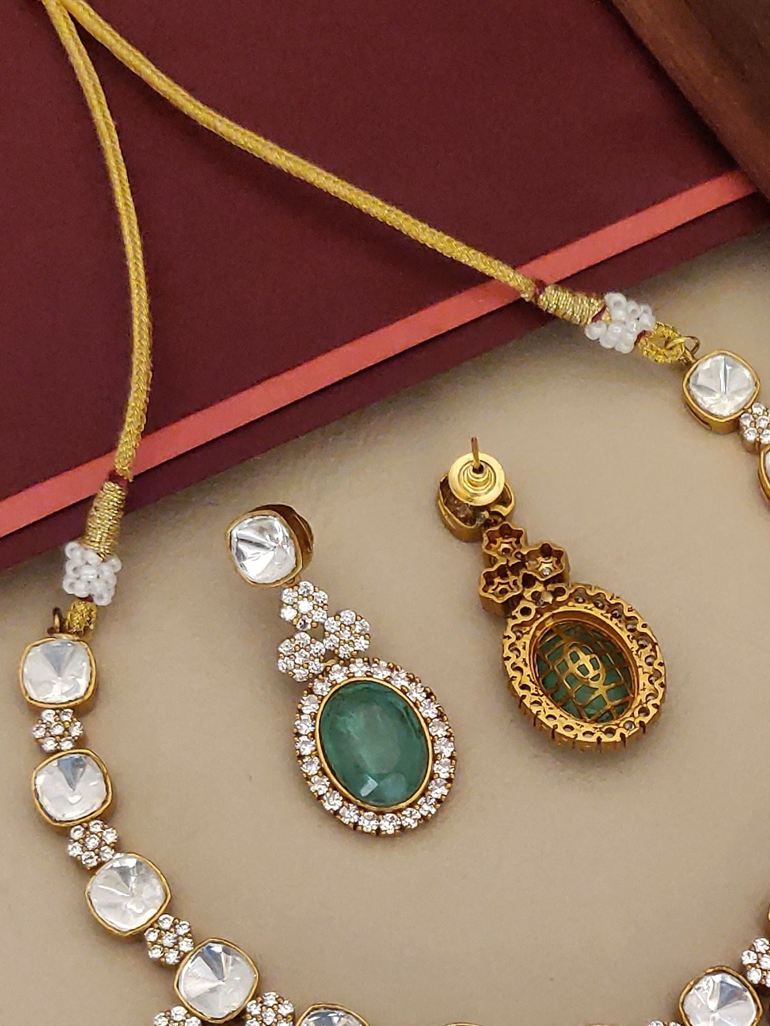 Gold Plated Polki Necklace Set featuring intricate designs and sparkling gems on a stylish background