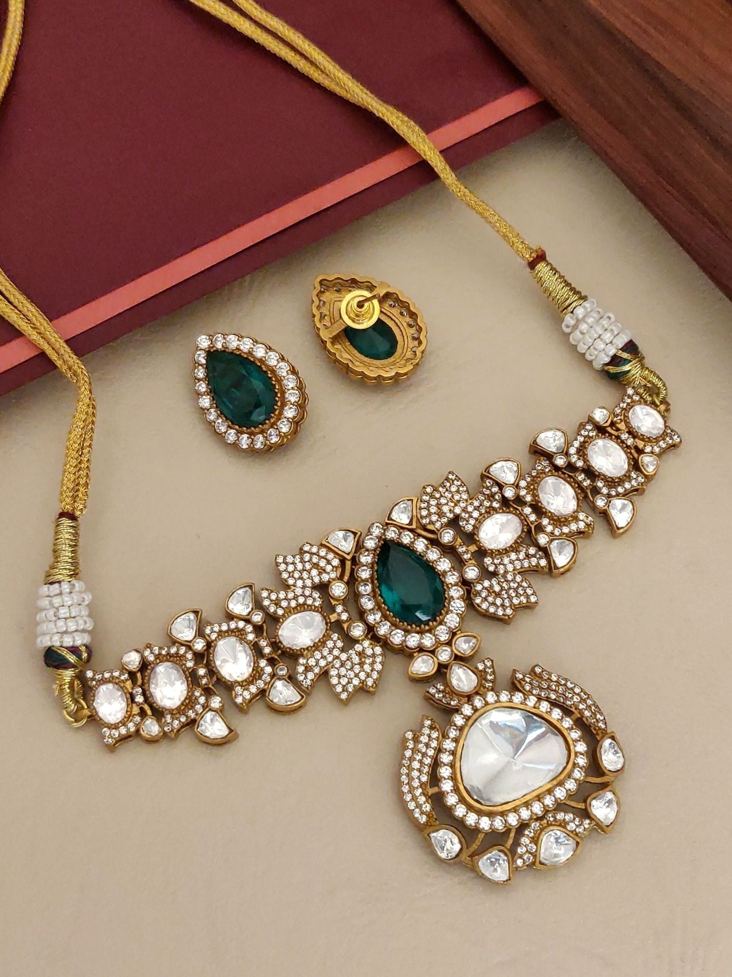 Elegant gold plated polki necklace set with intricate design and emerald accents, perfect for special occasions