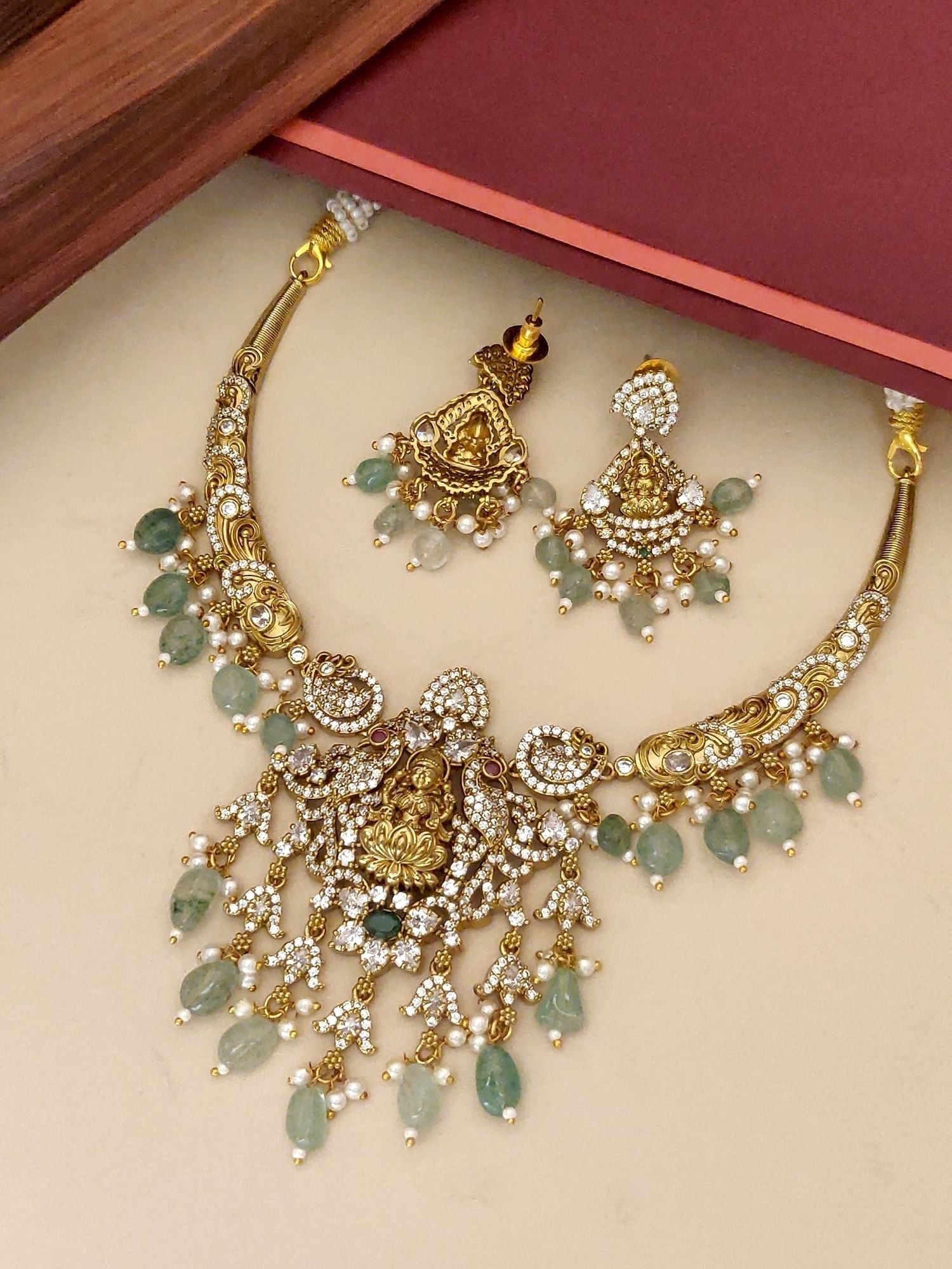 Gold Plated Temple Necklace Set with intricate design and matching earrings featuring green gemstones
