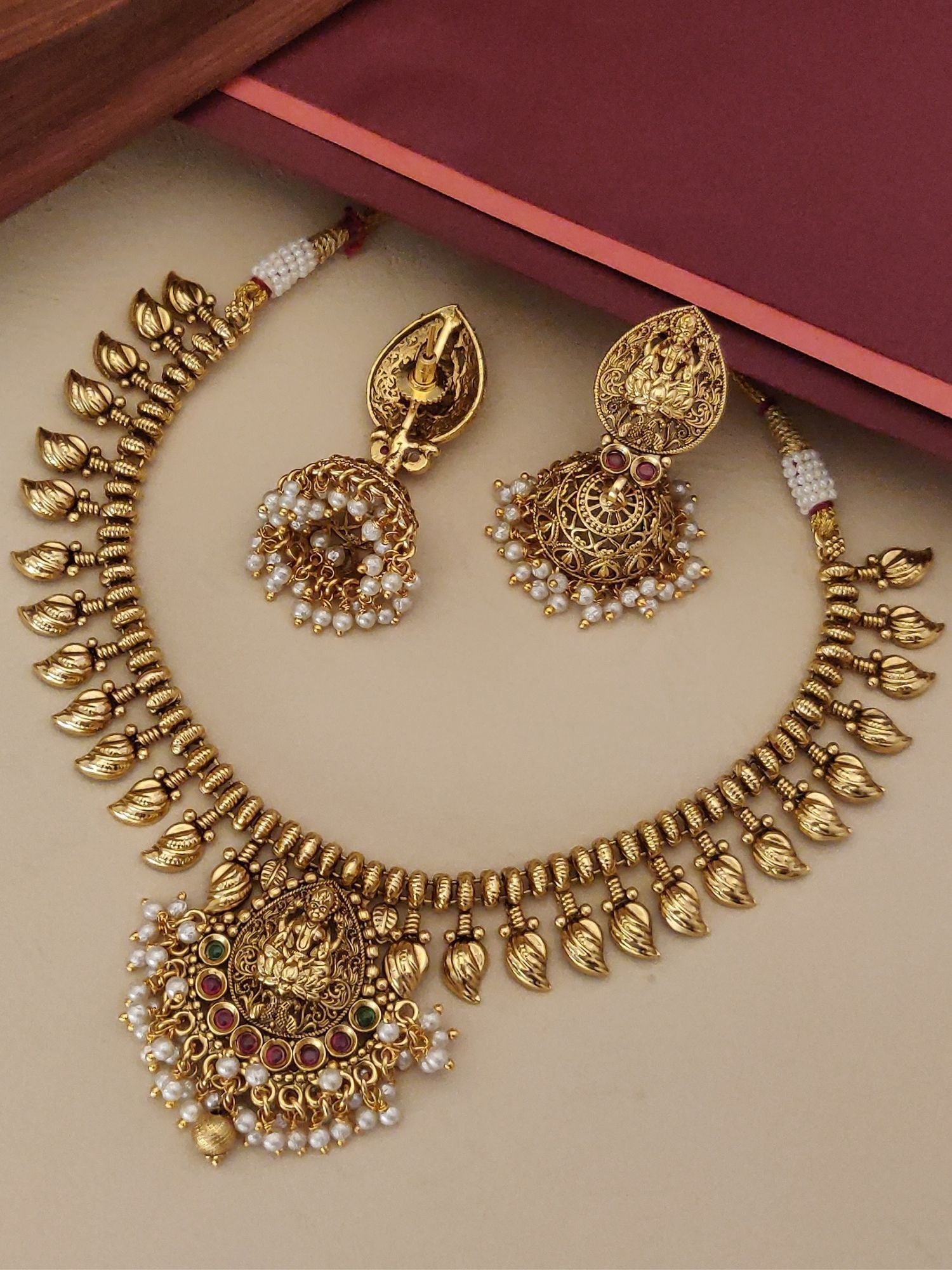 Gold plated temple necklace set featuring intricate designs and pearl accents, perfect for festive occasions